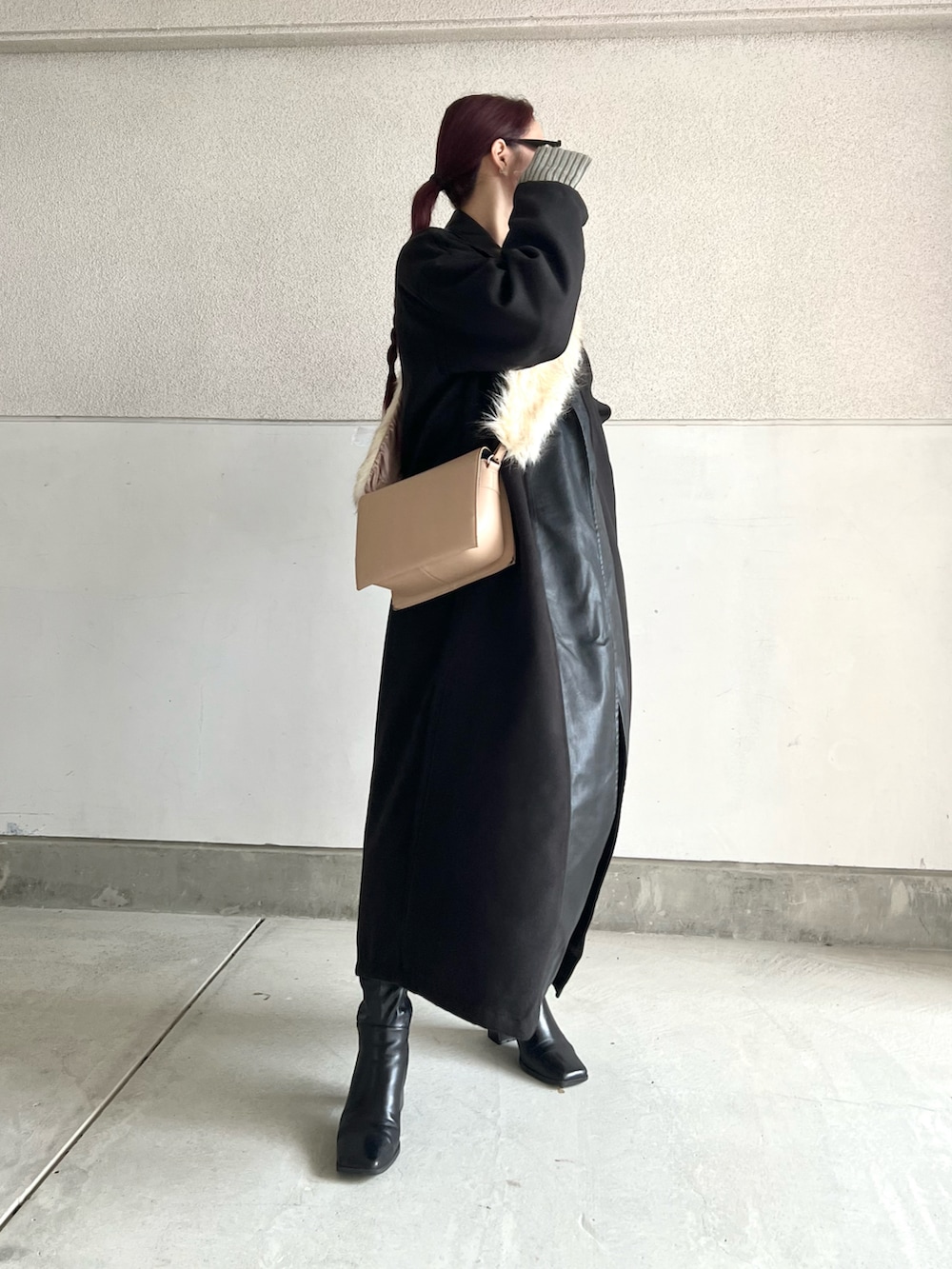 ブラック系のブーツ、ベージュ系のショルダーバッグ、ブラック系のジャケット/アウターを着用したレディースの冬コーディネートの5枚目の写真