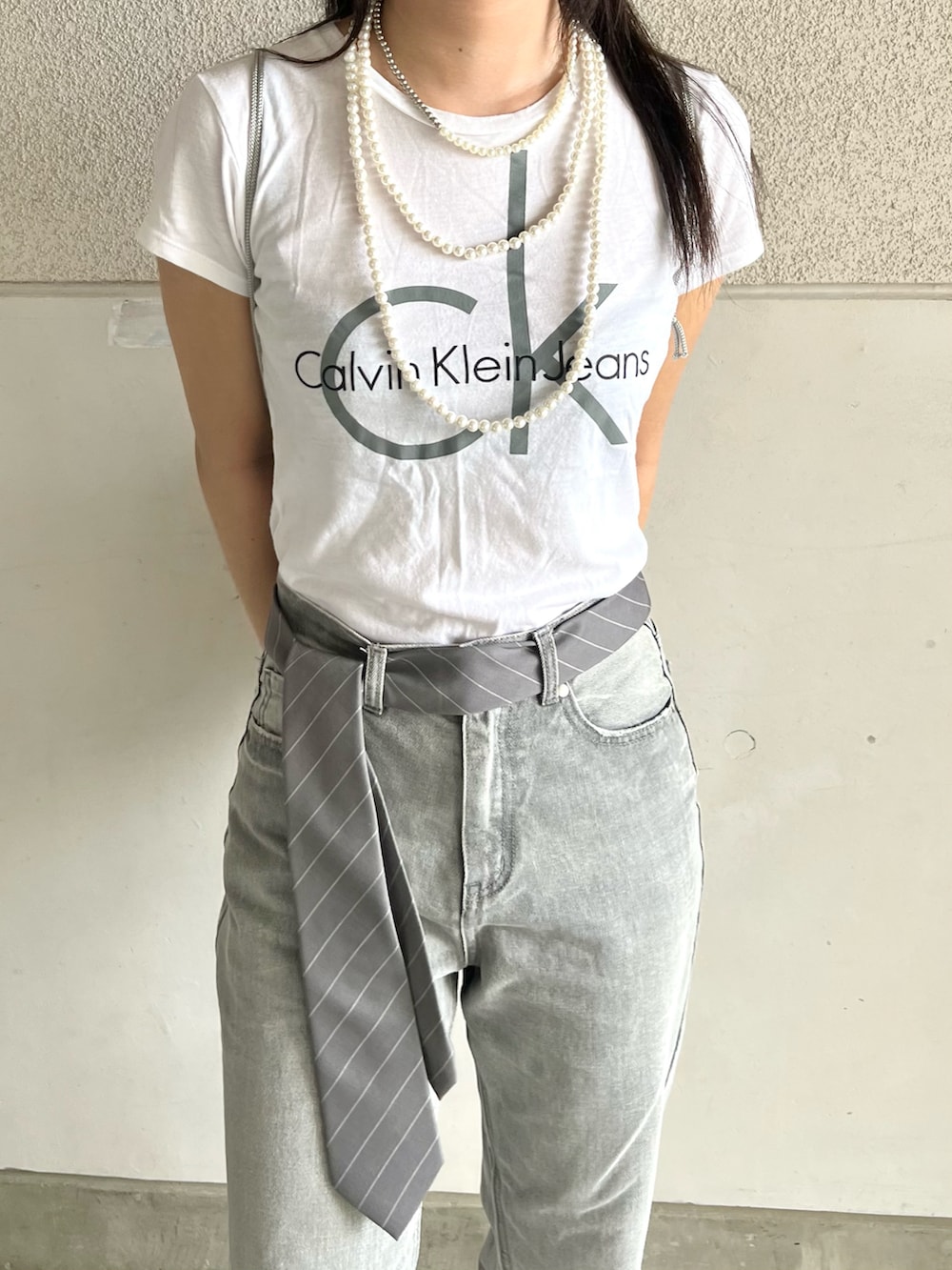 グレー系のパンツ、ホワイト系のTシャツ/カットソー、グレー系のネクタイを着用したレディースの秋コーディネートの2枚目の写真