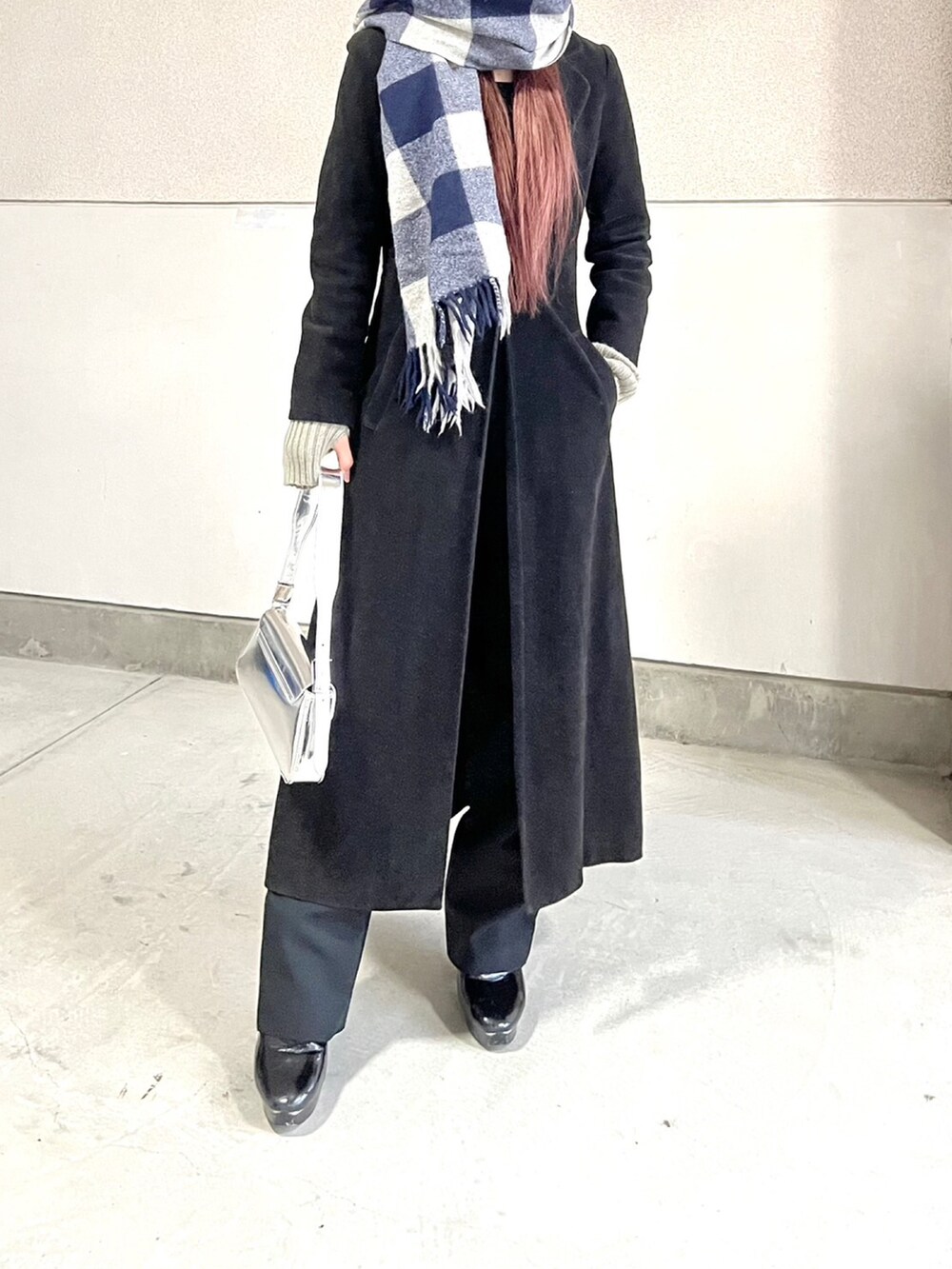 ブラック系のブーツ、シルバー系のハンドバッグ、ブラック系のジャケット/アウターを着用したレディースの冬コーディネートの3枚目の写真