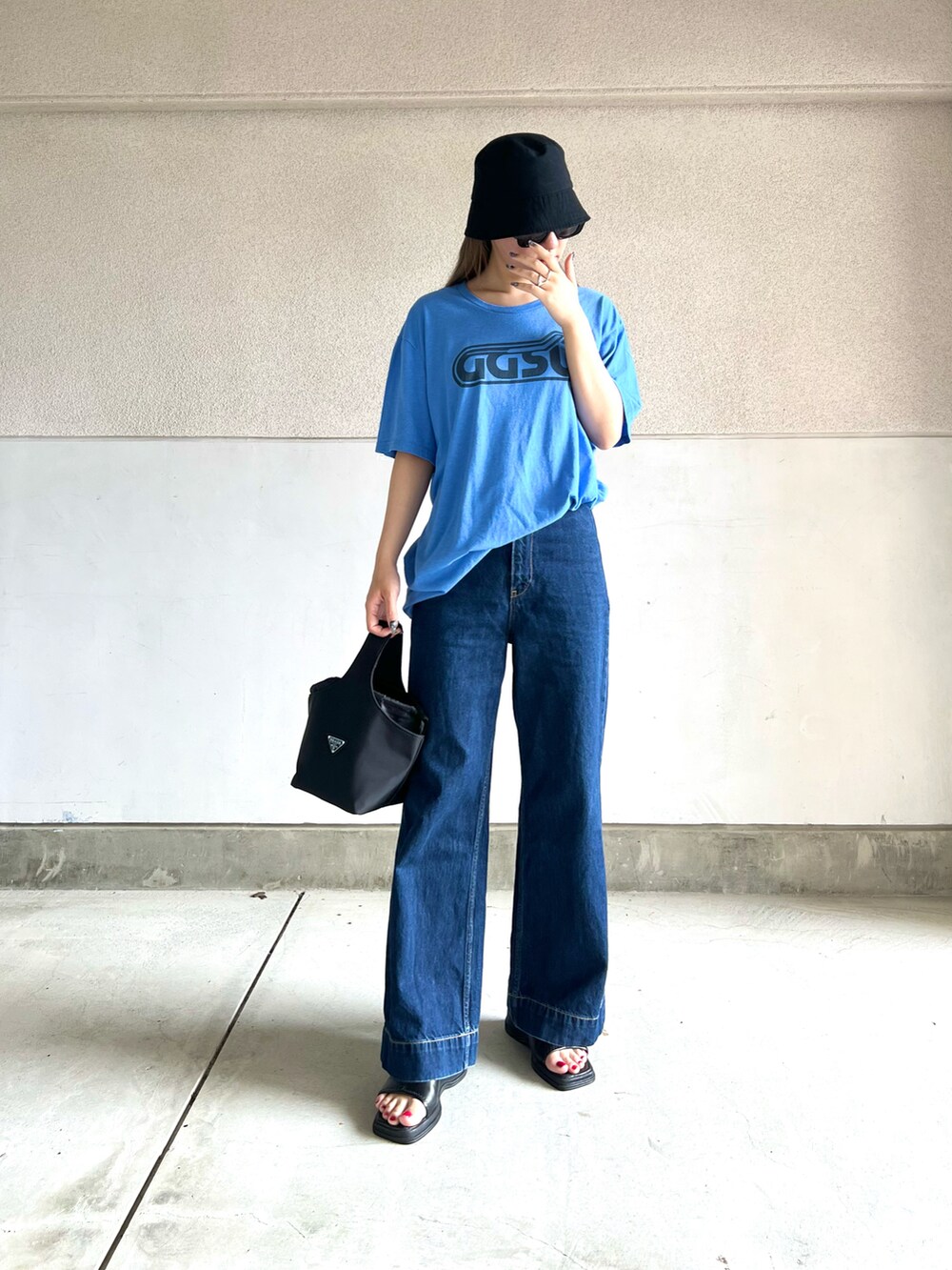 ブルー系のデニムパンツ、ブルー系のTシャツ/カットソー、ブラック系のバッグを着用したレディースの夏コーディネートの2枚目の写真