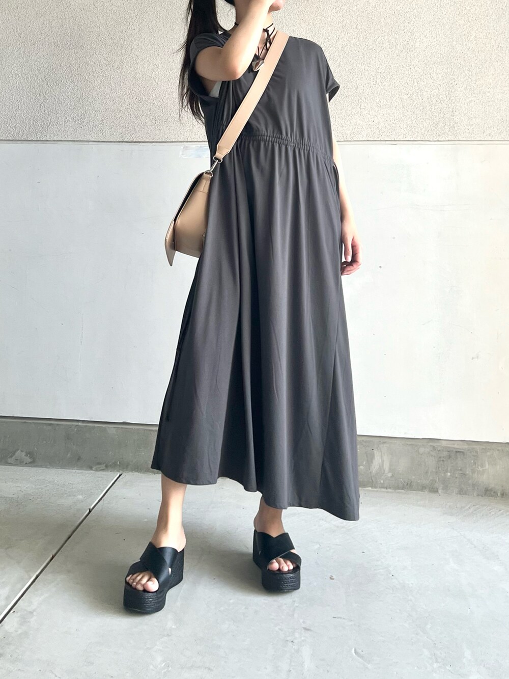 グレー系のワンピース、ベージュ系のショルダーバッグ、ブラック系のシューズを着用したレディースの夏コーディネートの3枚目の写真