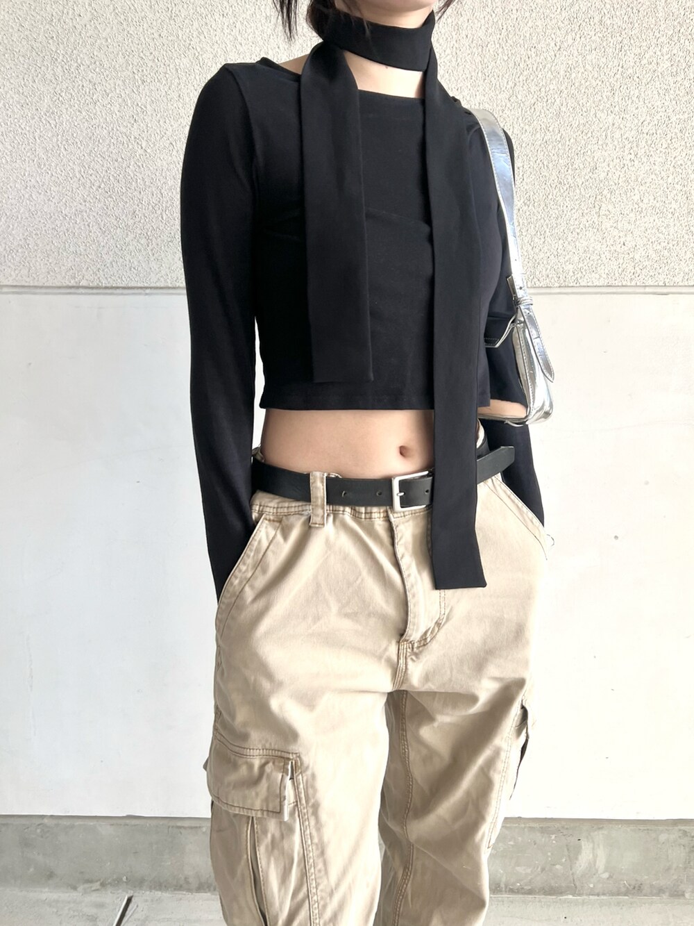 ベージュ系のカーゴパンツ、ブラック系のスニーカー、ブラック系のTシャツ/カットソーを着用したレディースの春コーディネートの2枚目の写真