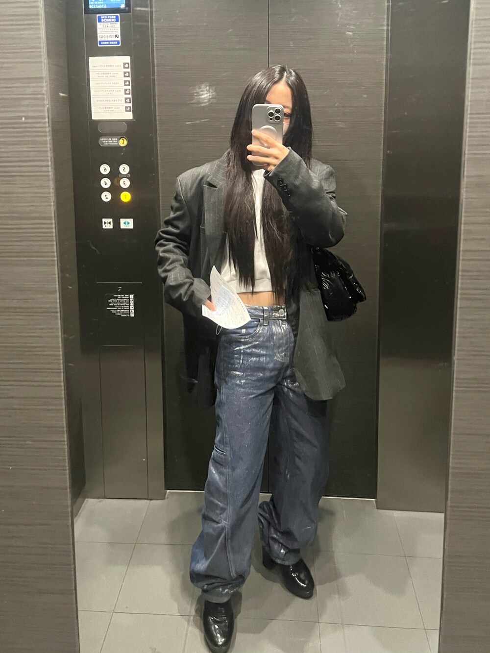 ブルー系のデニムパンツ、ブルー系のテーラードジャケット、ブラック系のトートバッグを着用したレディースの春コーディネートの5枚目の写真