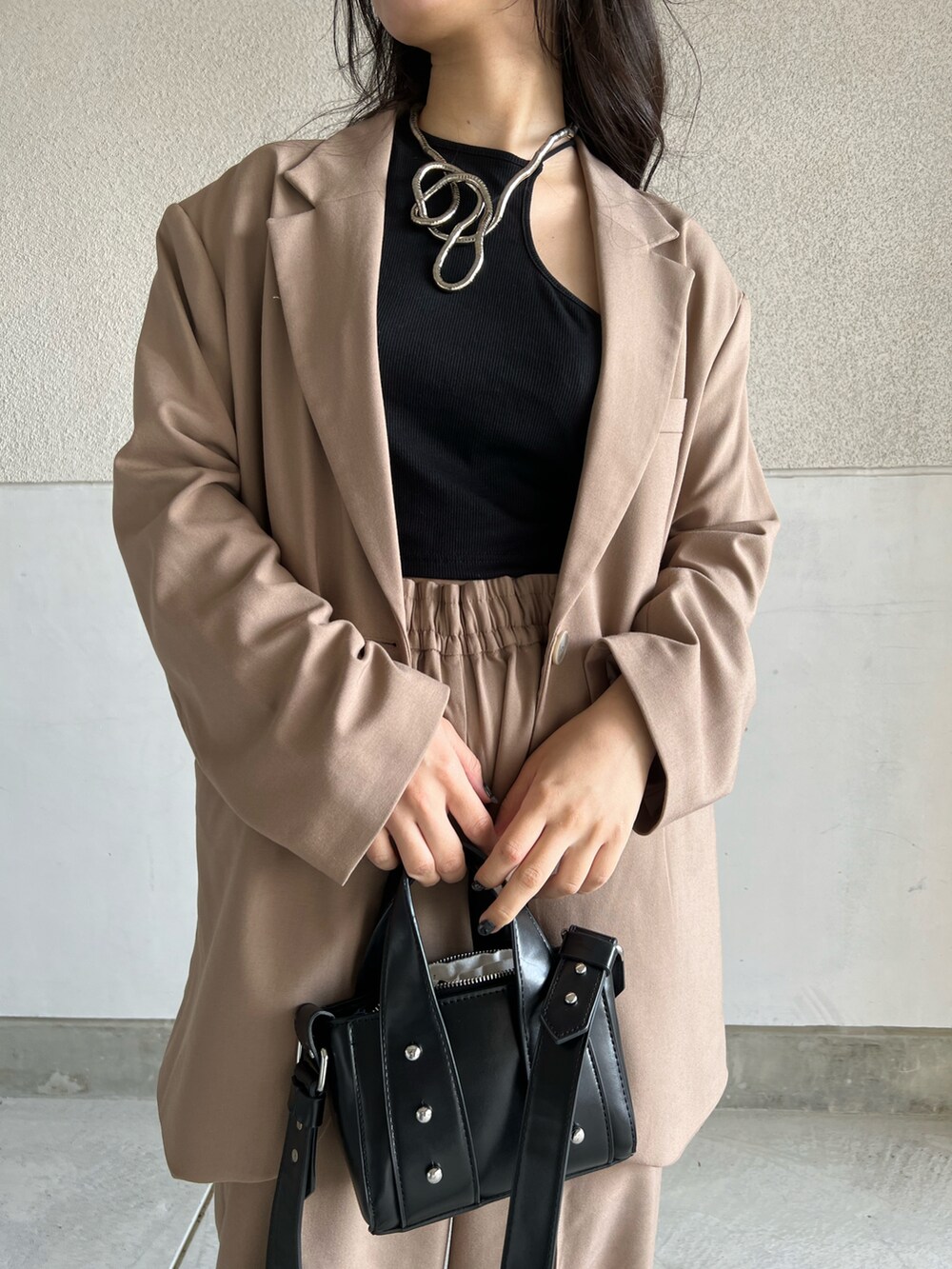 ブラウン系のパンツ、ブラック系のタンクトップ、ブラウン系のテーラードジャケットを着用したレディースの春コーディネートの4枚目の写真