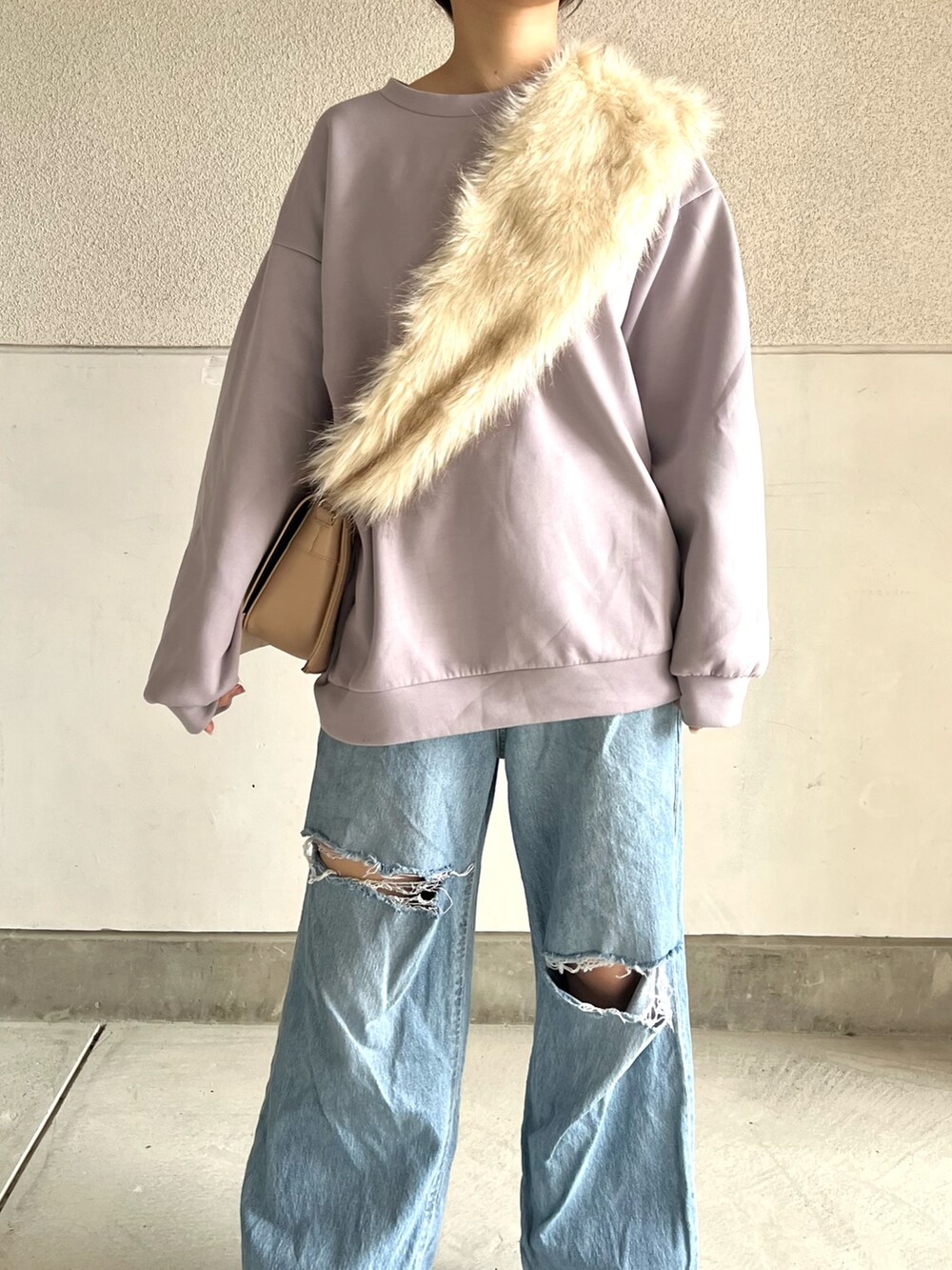 ブラック系のブーツ、ブルー系のデニムパンツ、パープル系のスウェットを着用したレディースの冬コーディネートの2枚目の写真