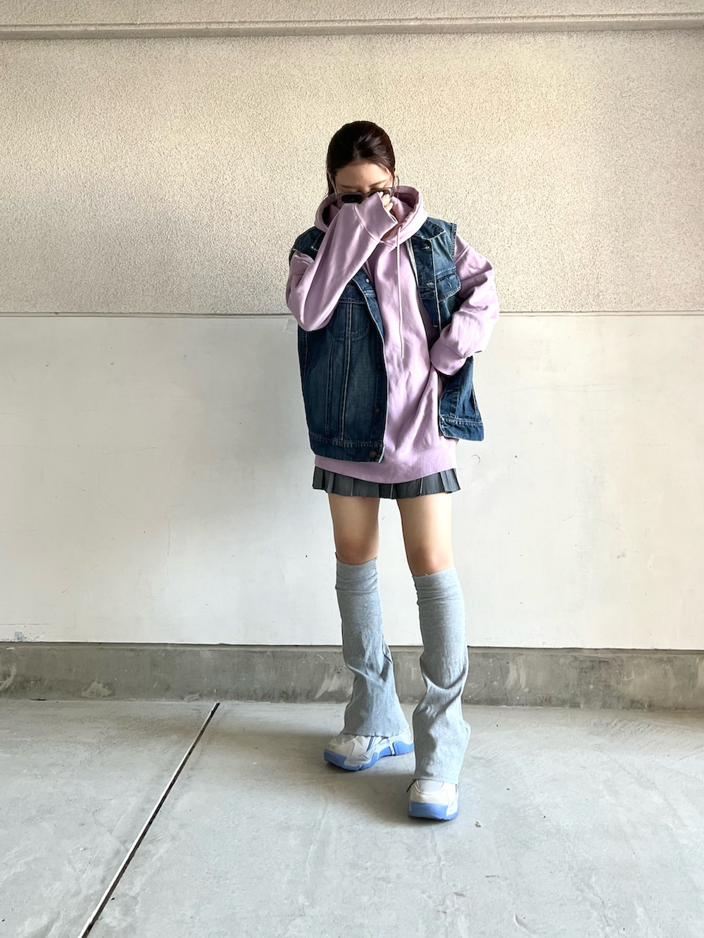 グレー系のスニーカー、ブルー系のデニムジャケット、パープル系のパーカーを着用したレディースの春コーディネートの3枚目の写真