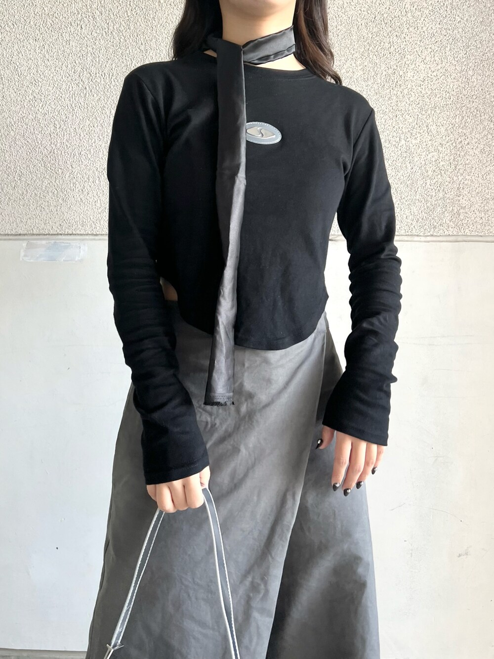 ブラック系のブーツ、グレー系のパンツ、ブラック系のTシャツ/カットソーを着用したレディースの春コーディネートの2枚目の写真