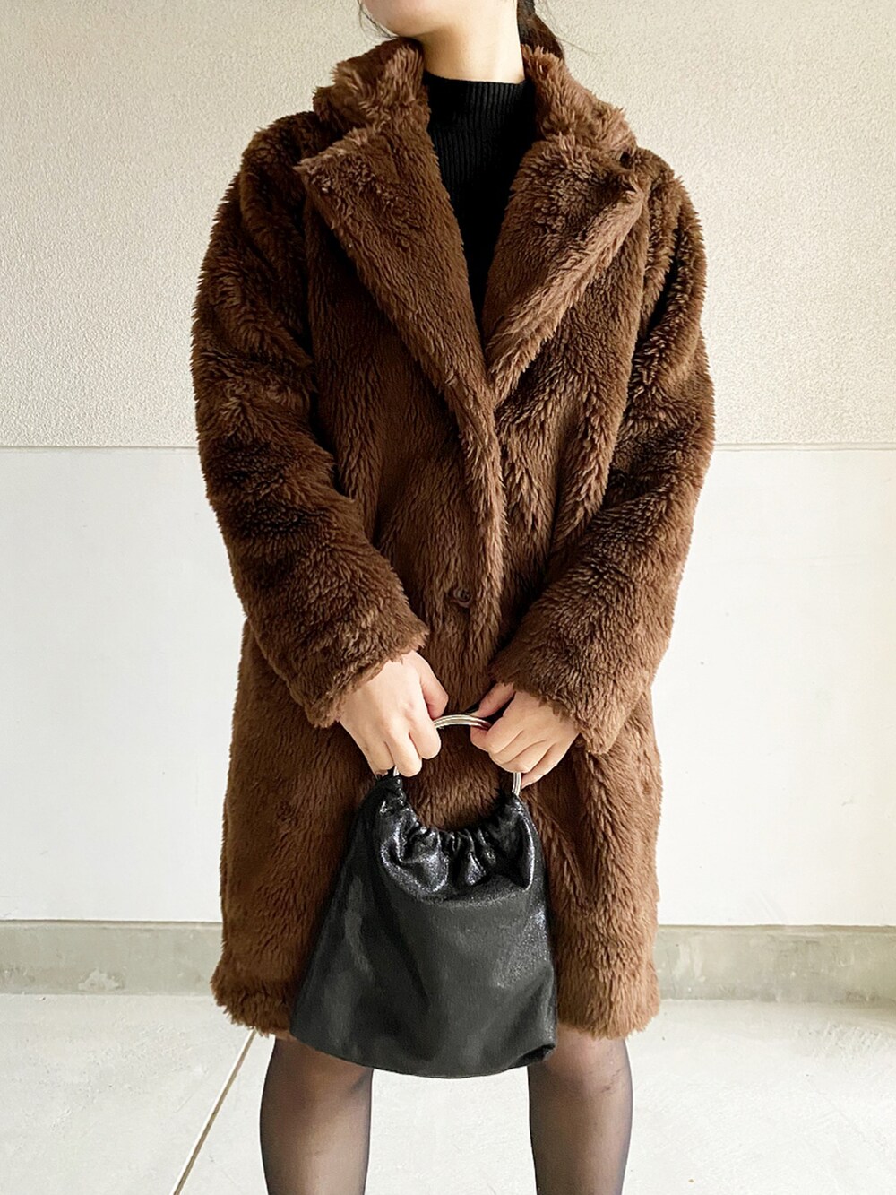 ブラウン系のジャケット/アウター、ブラック系のハンドバッグ、ブラック系のブーツを着用したレディースの冬コーディネートの2枚目の写真