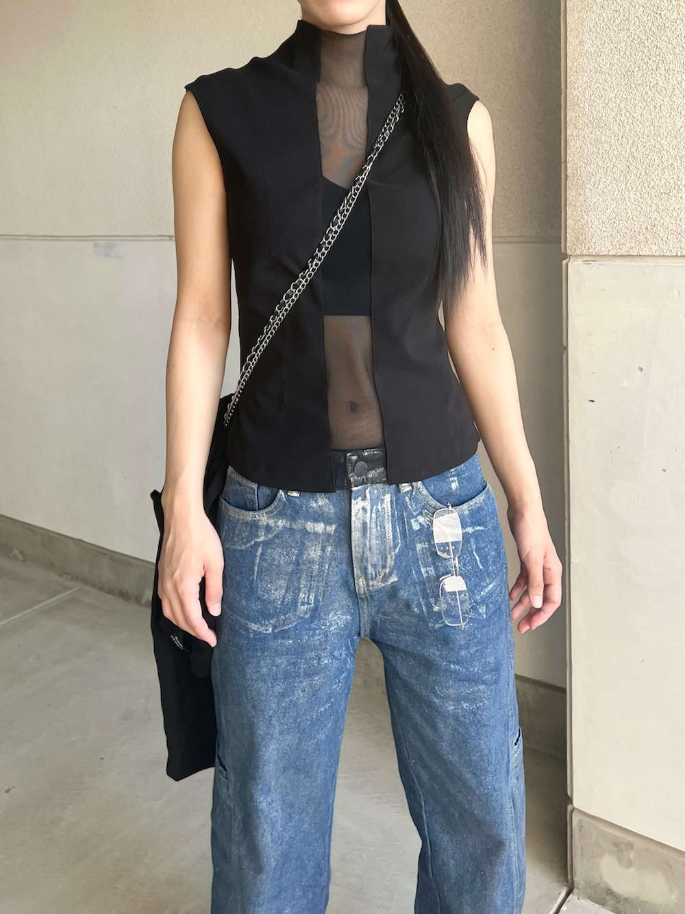 ブラック系のタンクトップ、ブルー系のデニムパンツ、ブラック系のサンダルを着用したレディースの夏コーディネートの2枚目の写真