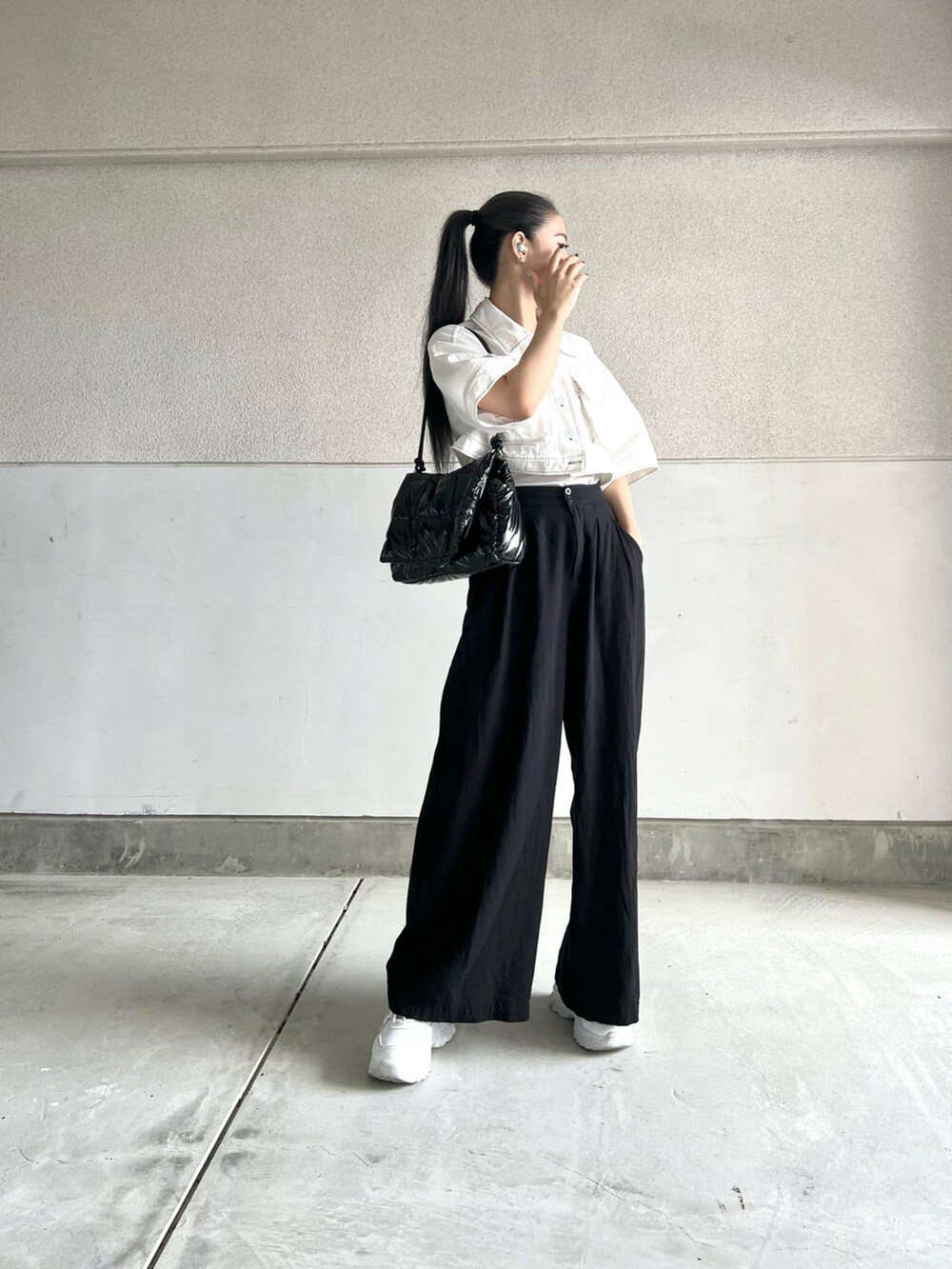 ブラック系のトートバッグ、ブラック系のその他パンツ、ホワイト系のスニーカーを着用したレディースの秋コーディネートの2枚目の写真