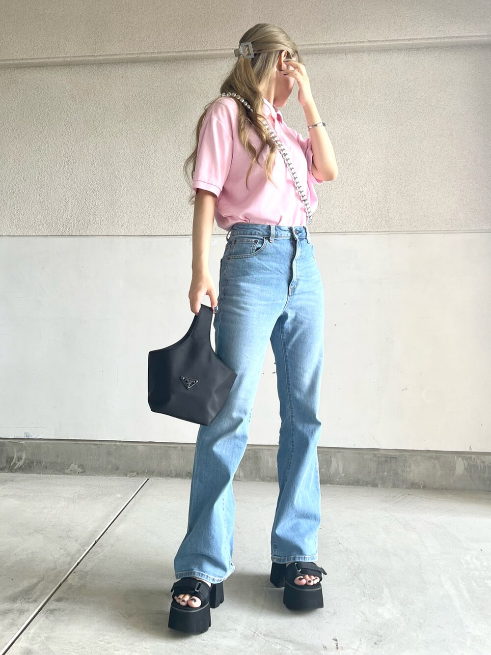 ピンク系のポロシャツ、ブルー系のパンツ、ブラック系のサンダルを着用したレディースの夏コーディネートの2枚目の写真