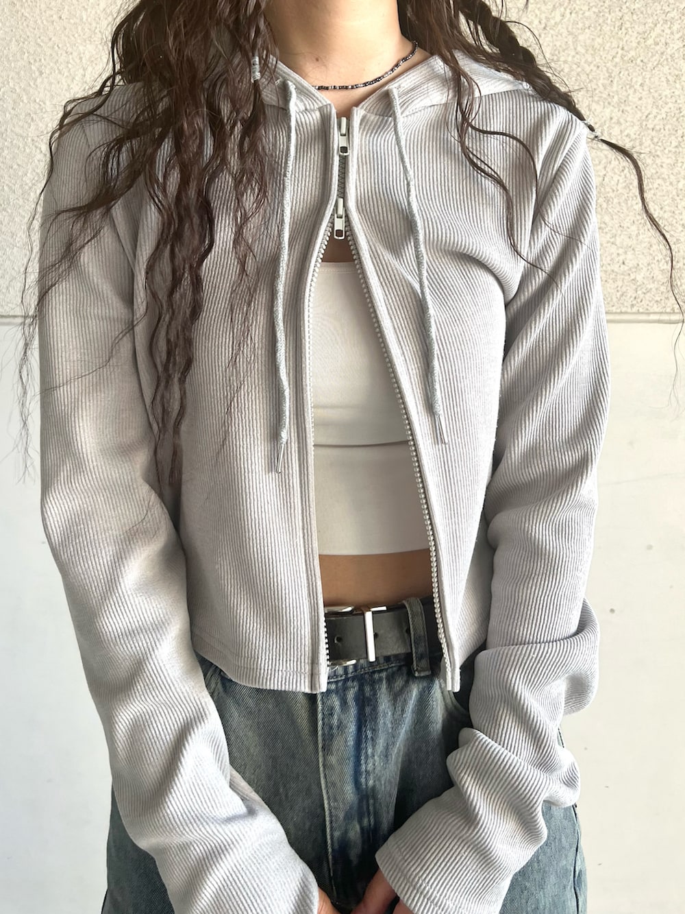 グレー系のスニーカー、グレー系のパーカー、ブルー系のデニムパンツを着用したレディースの春コーディネートの5枚目の写真