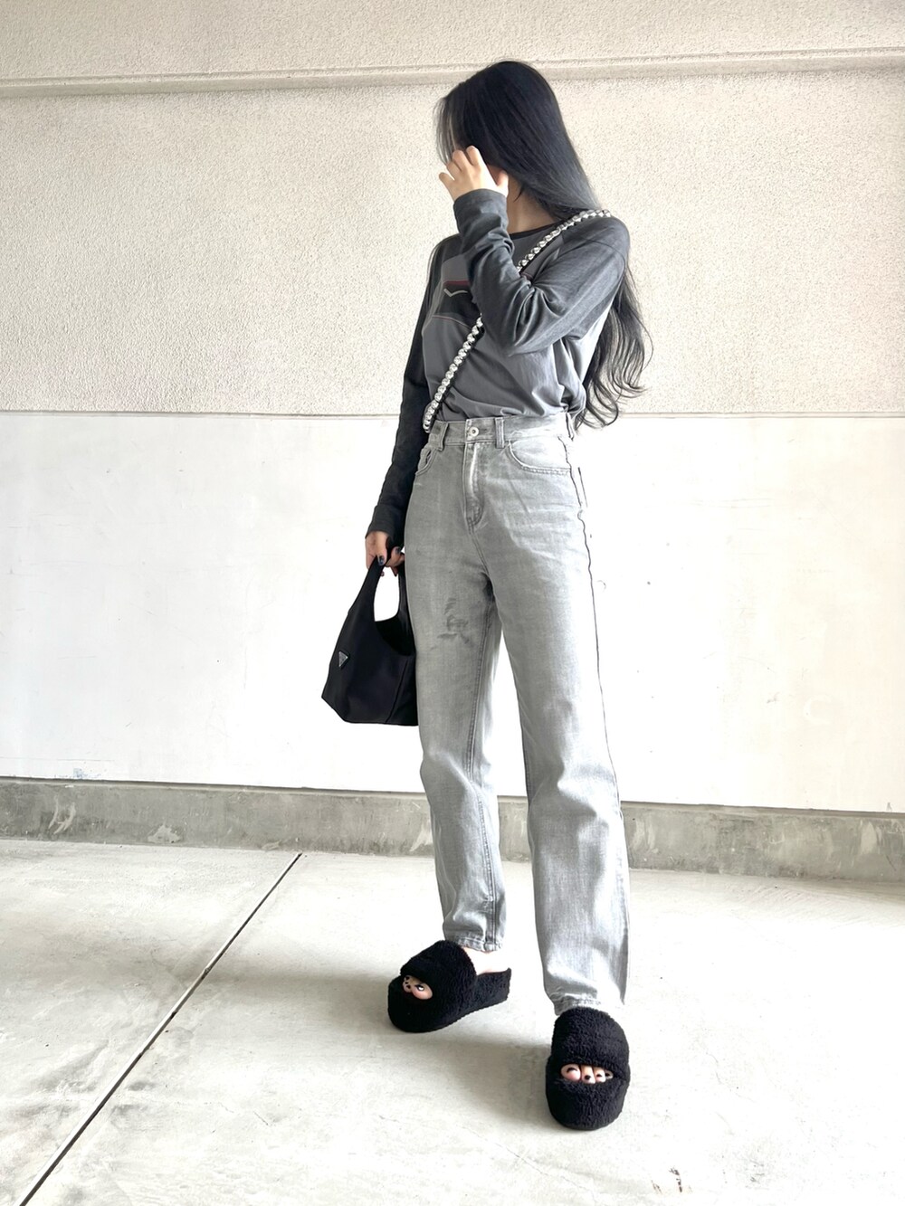 ブラック系のバッグ、グレー系のトップス、グレー系のパンツを着用したレディースの夏コーディネートの2枚目の写真