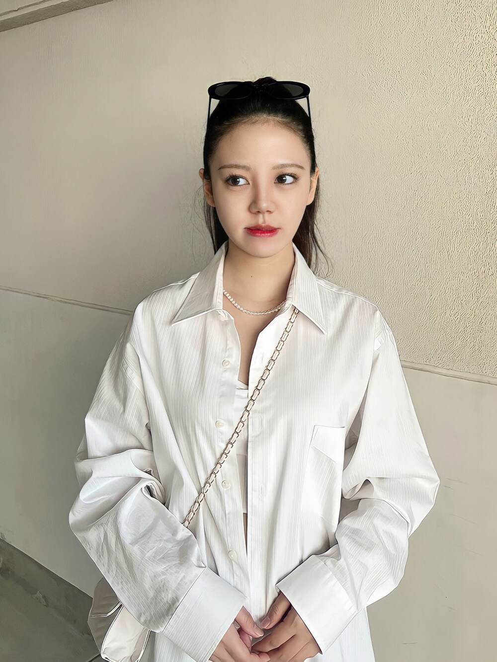 グレー系のスニーカー、ホワイト系のシャツ/ブラウス、ホワイト系のショルダーバッグを着用したレディースの夏コーディネートの4枚目の写真