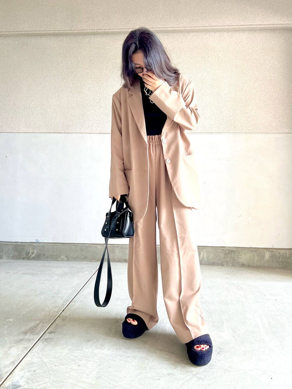 ブラウン系のパンツ、ブラック系のタンクトップ、ブラウン系のテーラードジャケットを着用したレディースの春コーディネートの3枚目の写真