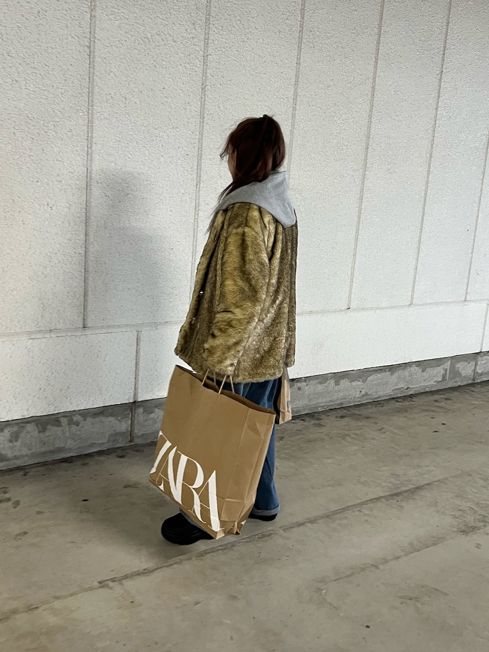 ブラウン系のスリッポン、ベージュ系のその他アウター、グレー系のパーカーを着用したレディースの冬コーディネートの5枚目の写真