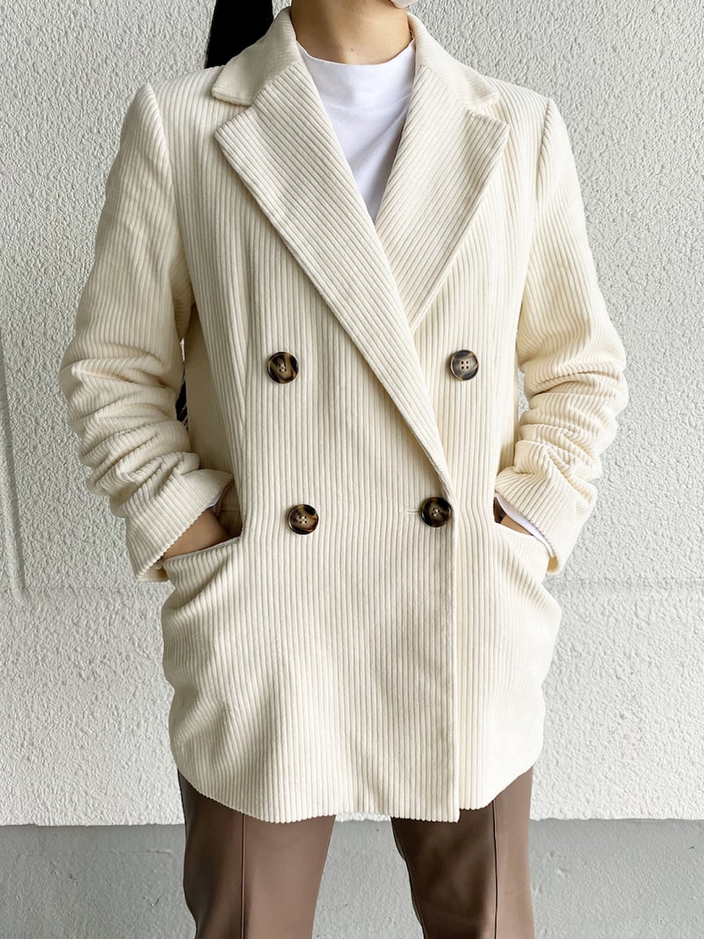 ブラウン系のその他パンツ、ブラック系のブーツ、ホワイト系のテーラードジャケットを着用したレディースの冬コーディネートの3枚目の写真