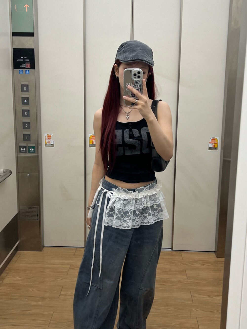 ブラック系のキャミソール、ブルー系のデニムパンツ、ブラウン系のバッグを着用したレディースの夏コーディネートの4枚目の写真