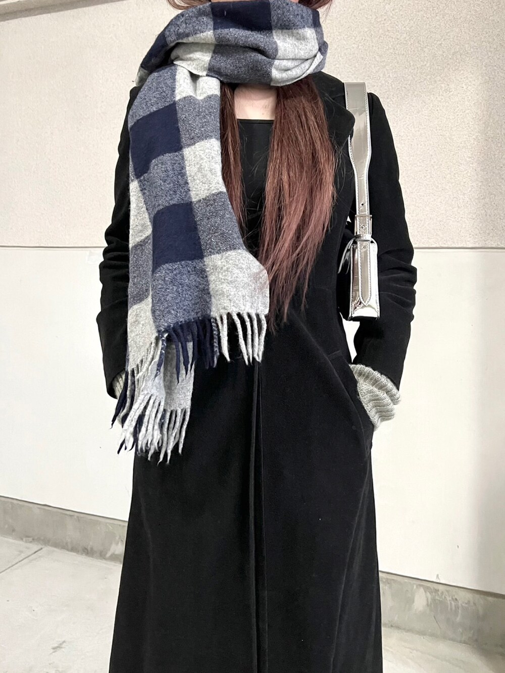 ブラック系のブーツ、シルバー系のハンドバッグ、ブラック系のジャケット/アウターを着用したレディースの冬コーディネートの2枚目の写真