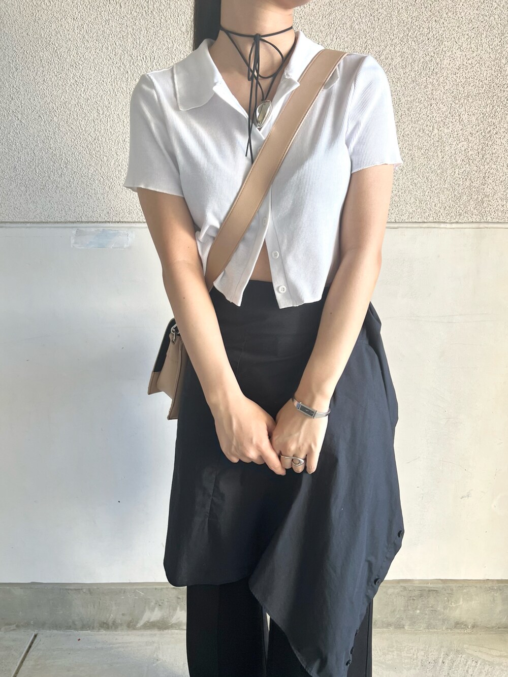 ベージュ系のショルダーバッグ、ブルー系のデニムパンツ、ブラック系のサンダルを着用したレディースの夏コーディネートの2枚目の写真