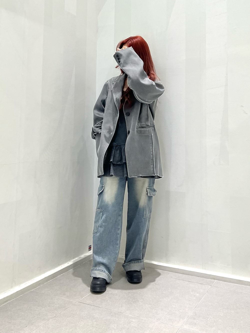 グレー系のテーラードジャケット、ブラック系のその他シューズ、ブルー系のデニムパンツを着用したレディースの春コーディネートの2枚目の写真