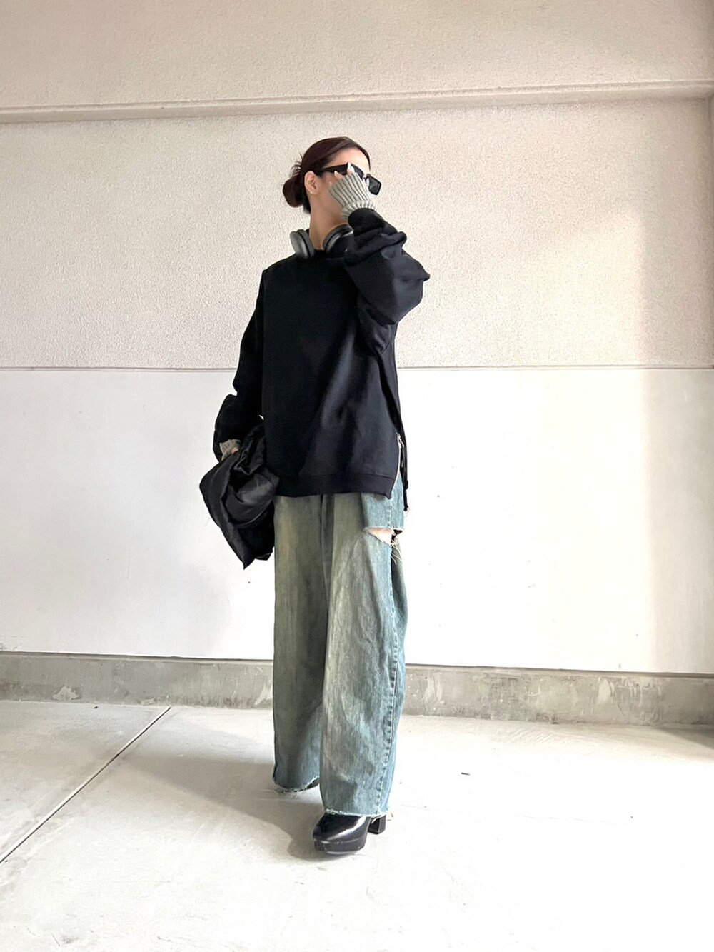 ブラック系のブーツ、ブルー系のデニムパンツ、ブラック系のトップスを着用したレディースの冬コーディネートの4枚目の写真