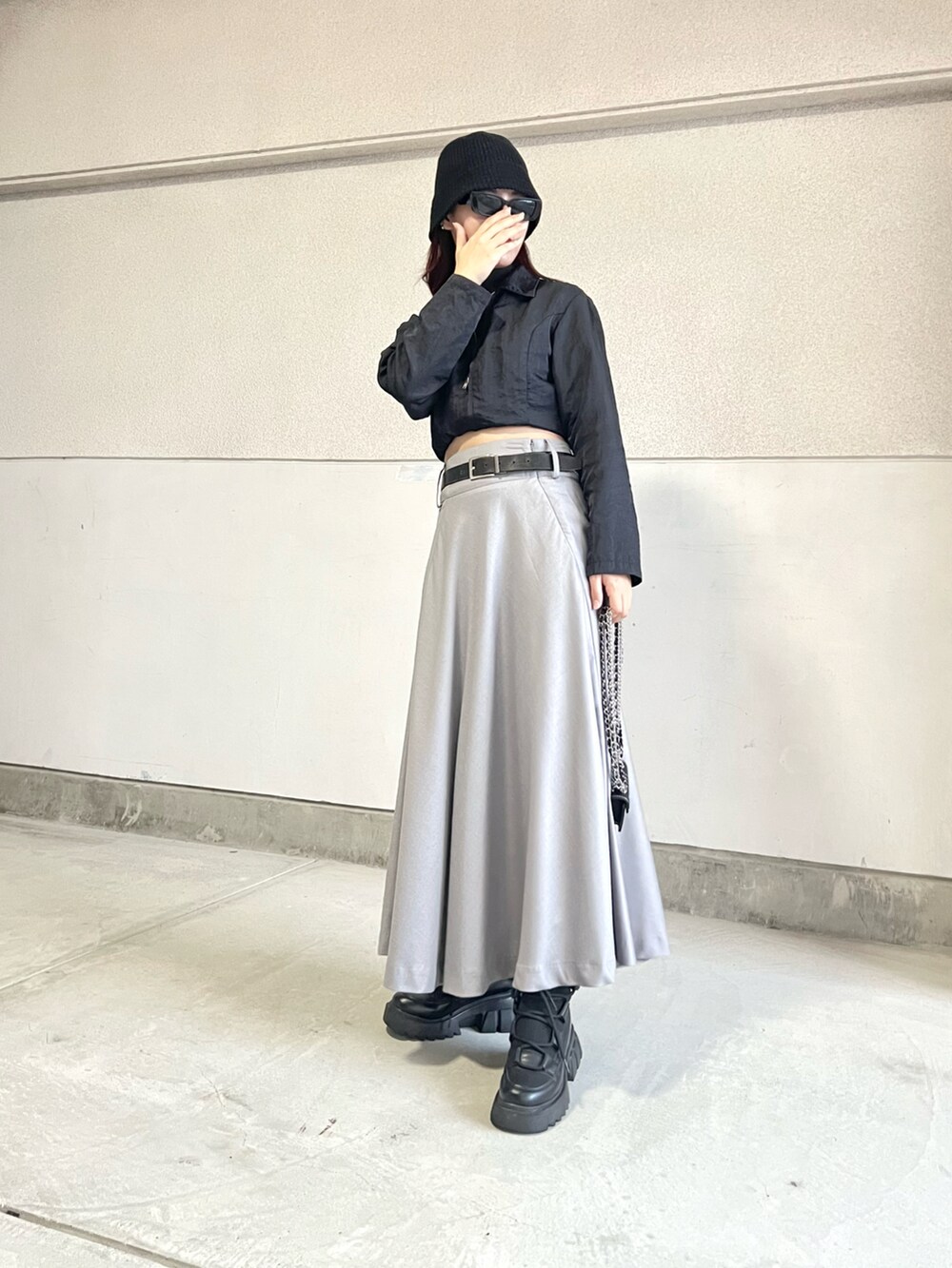 グレー系のスカート、ブラック系のブーツ、ブラック系のジャケット/アウターを着用したレディースの秋コーディネートの3枚目の写真