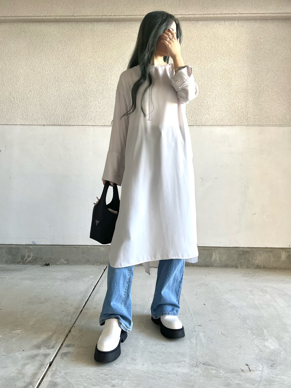 ブルー系のパンツ、ベージュ系のワンピース、ホワイト系のシューズを着用したレディースの秋コーディネートの2枚目の写真