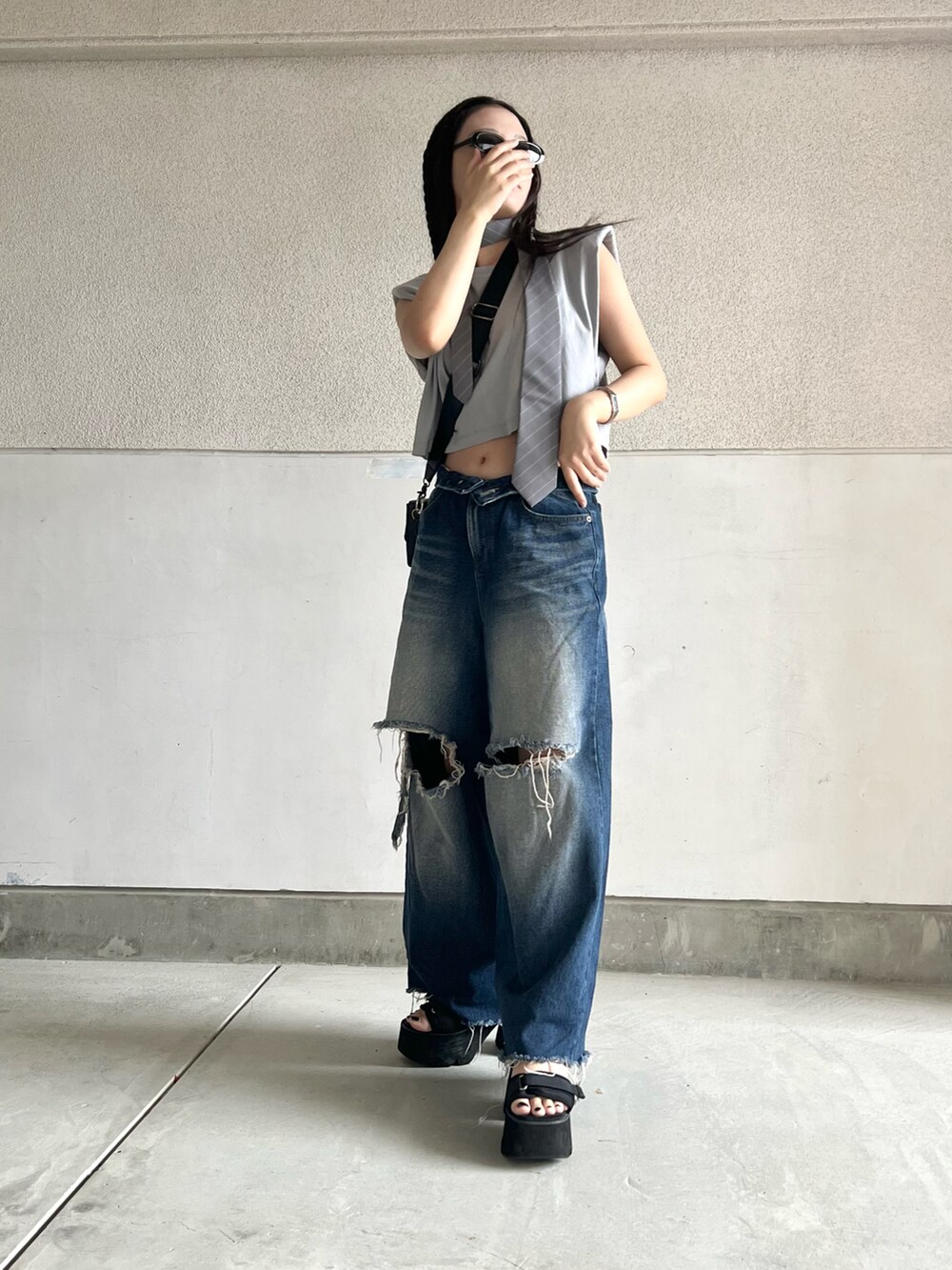 ブラック系のサンダル、グレー系のTシャツ/カットソー、ブルー系のデニムパンツを着用したレディースの夏コーディネートの4枚目の写真