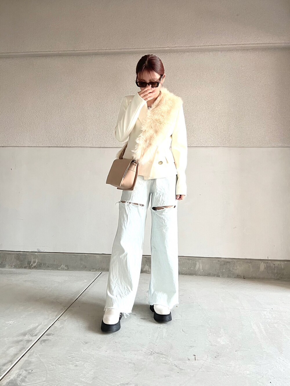 ホワイト系のシューズ、ブルー系のデニムパンツ、ホワイト系のテーラードジャケットを着用したレディースの冬コーディネートの4枚目の写真