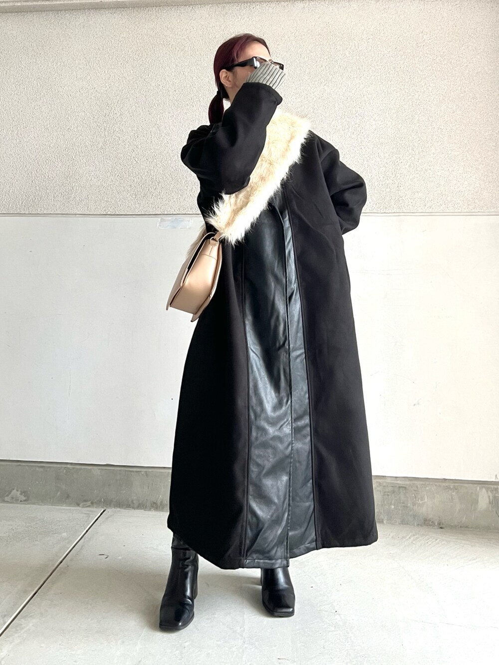 ブラック系のブーツ、ベージュ系のショルダーバッグ、ブラック系のジャケット/アウターを着用したレディースの冬コーディネートの4枚目の写真