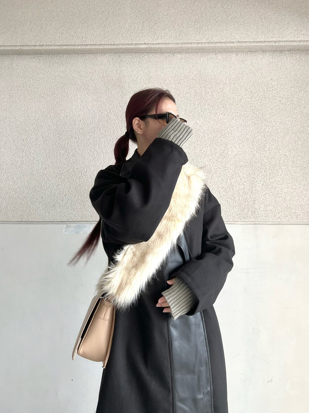 ブラック系のブーツ、ベージュ系のショルダーバッグ、ブラック系のジャケット/アウターを着用したレディースの冬コーディネートの2枚目の写真