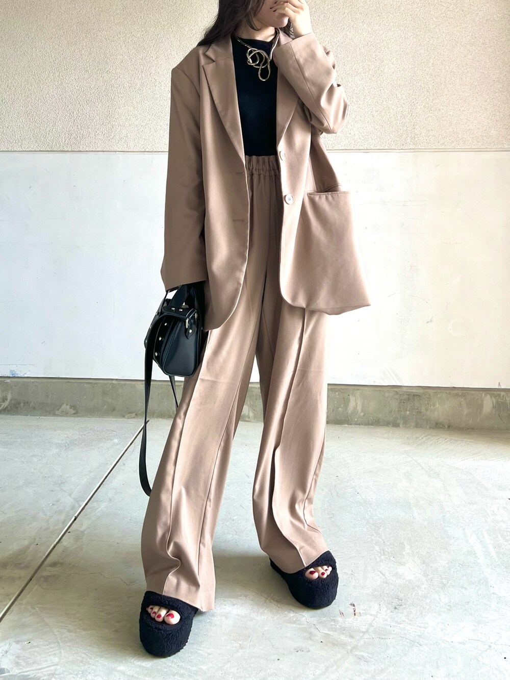 ブラウン系のパンツ、ブラック系のタンクトップ、ブラウン系のテーラードジャケットを着用したレディースの春コーディネートの2枚目の写真