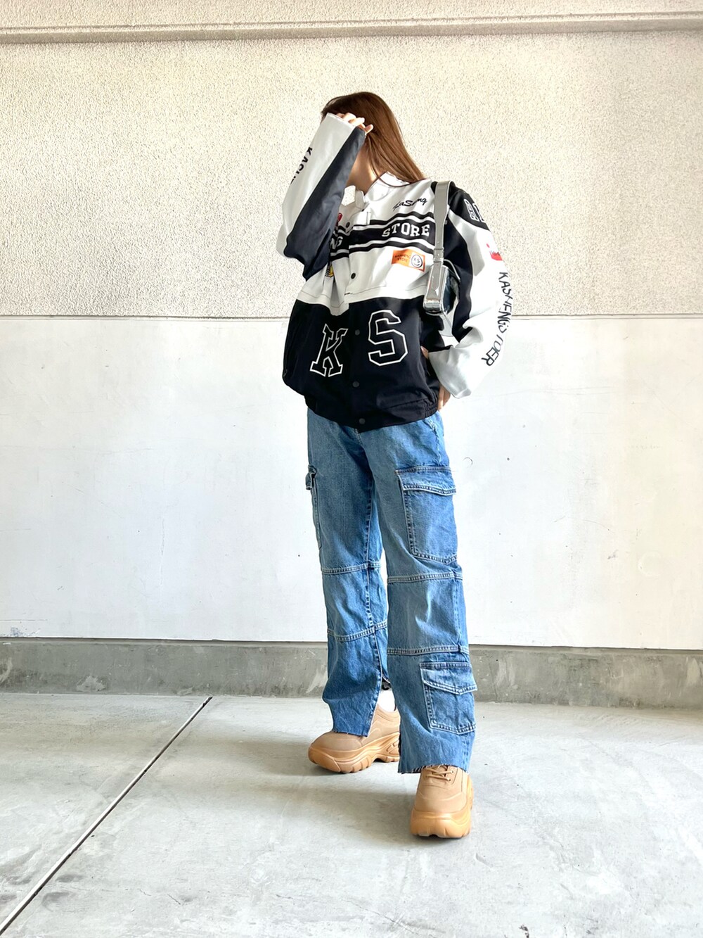 ブルー系のデニムパンツ、イエロー系のスニーカー、ホワイト系のジャケット/アウターを着用したレディースの冬コーディネートの3枚目の写真