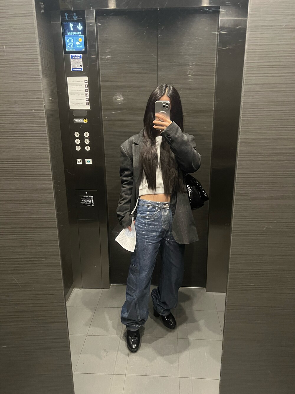 ブルー系のデニムパンツ、ブルー系のテーラードジャケット、ブラック系のトートバッグを着用したレディースの春コーディネートの4枚目の写真