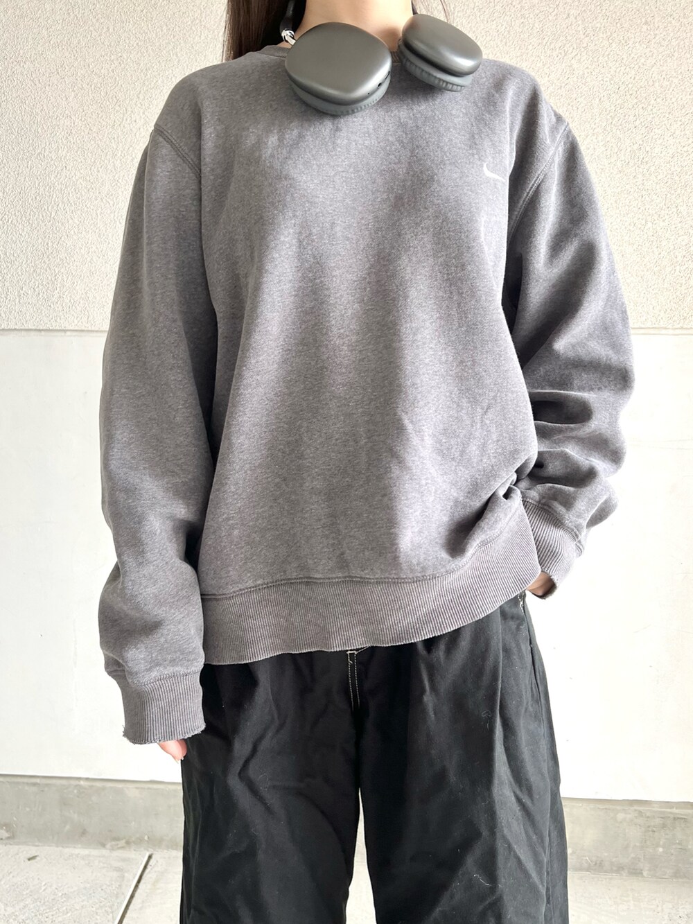 グレー系のスウェット、ブラック系のパンツ、ブラック系のブーツを着用したレディースの秋コーディネートの4枚目の写真