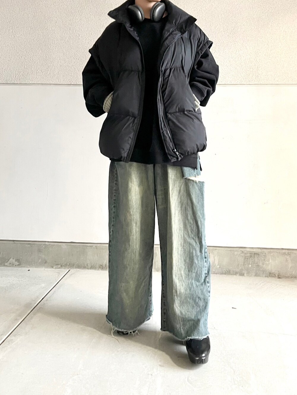 ブラック系のブーツ、ブルー系のデニムパンツ、ブラック系のトップスを着用したレディースの冬コーディネートの3枚目の写真