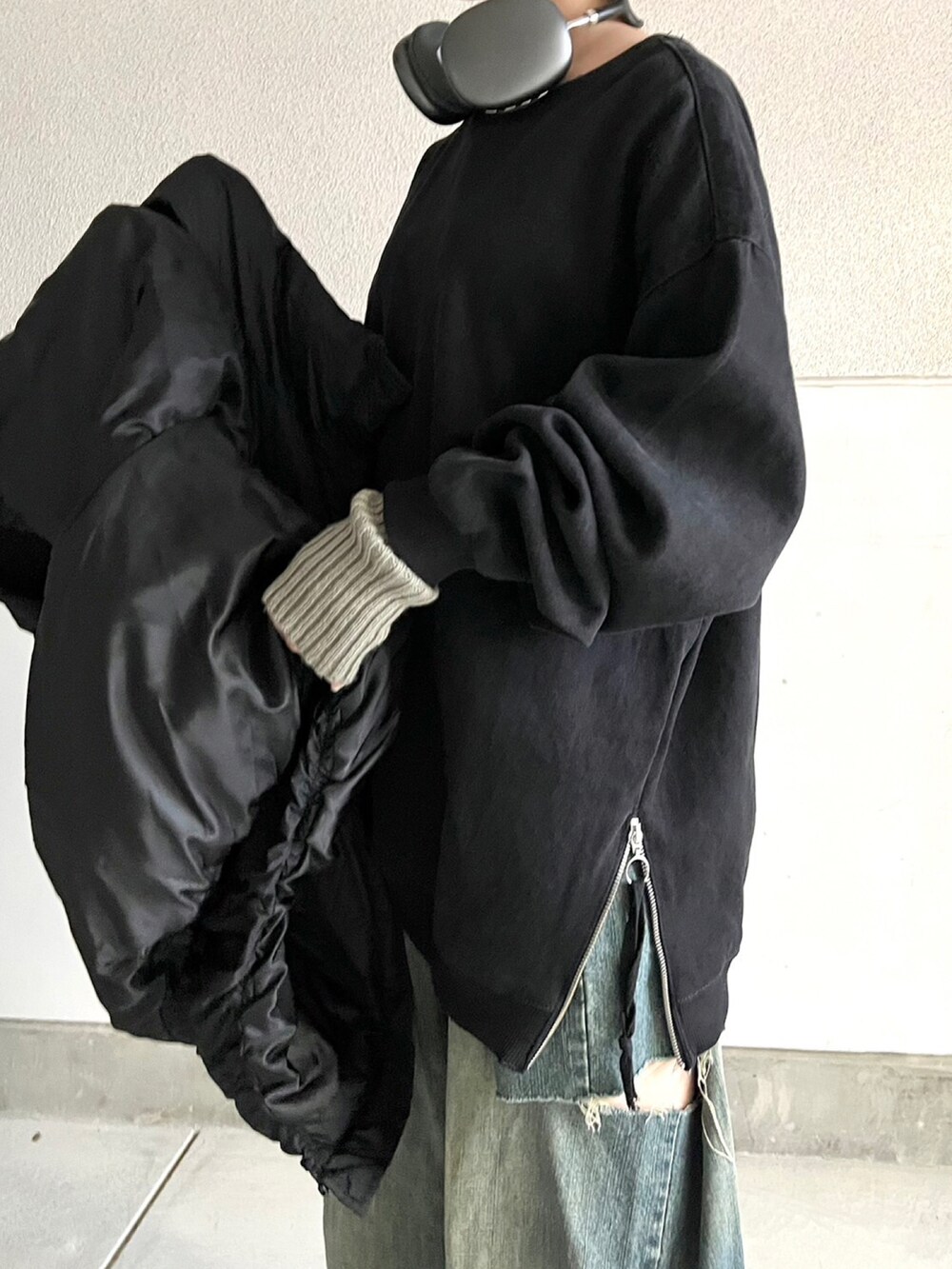 ブラック系のブーツ、ブルー系のデニムパンツ、ブラック系のトップスを着用したレディースの冬コーディネートの2枚目の写真