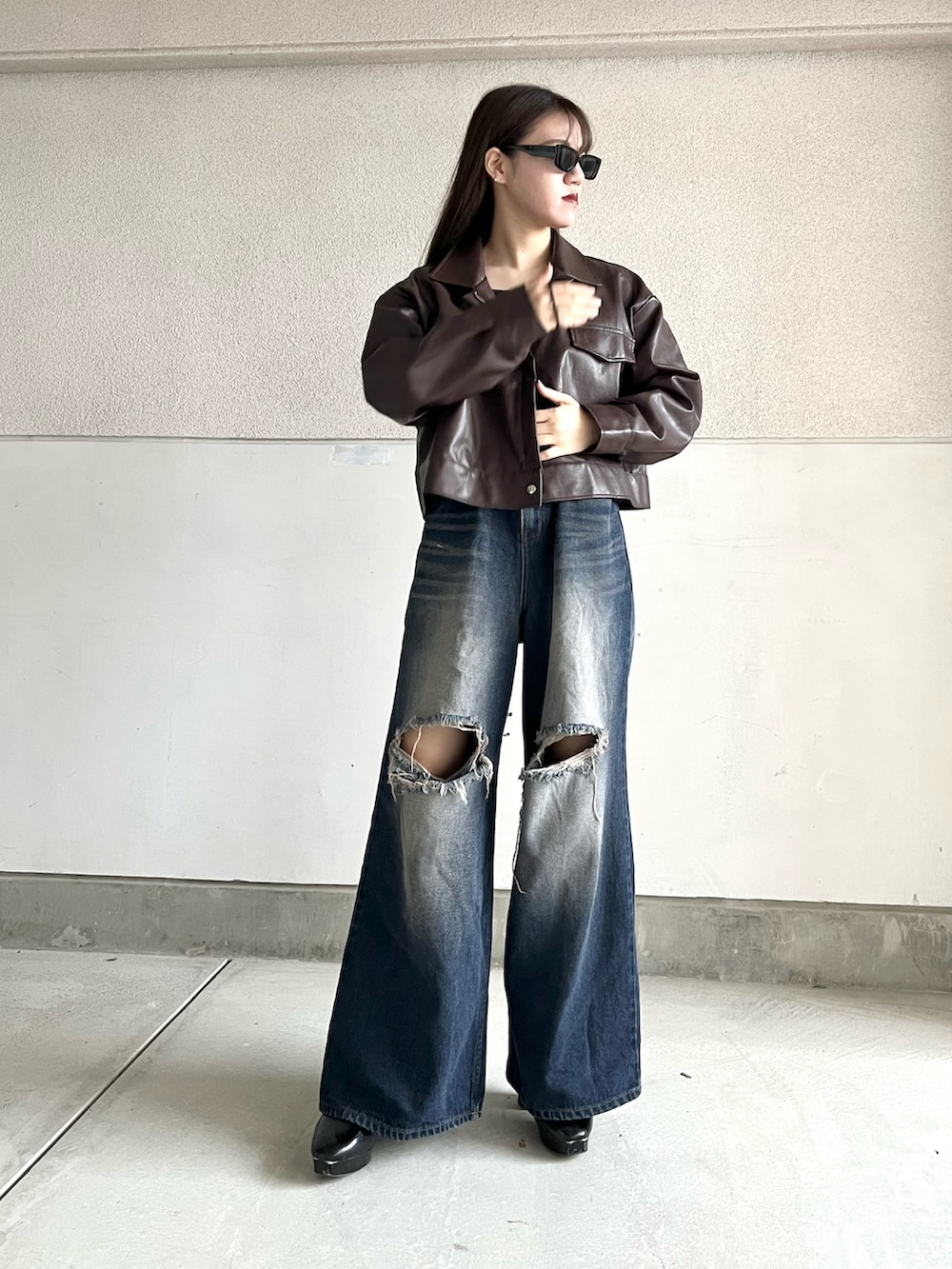 ブラック系のブーツ、ブルー系のデニムパンツ、ブラウン系のジャケット/アウターを着用したレディースの秋コーディネートの3枚目の写真