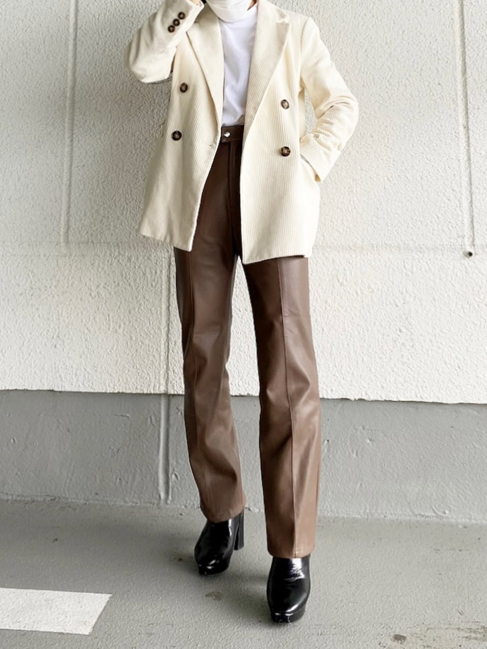 ブラウン系のその他パンツ、ブラック系のブーツ、ホワイト系のテーラードジャケットを着用したレディースの冬コーディネートの2枚目の写真