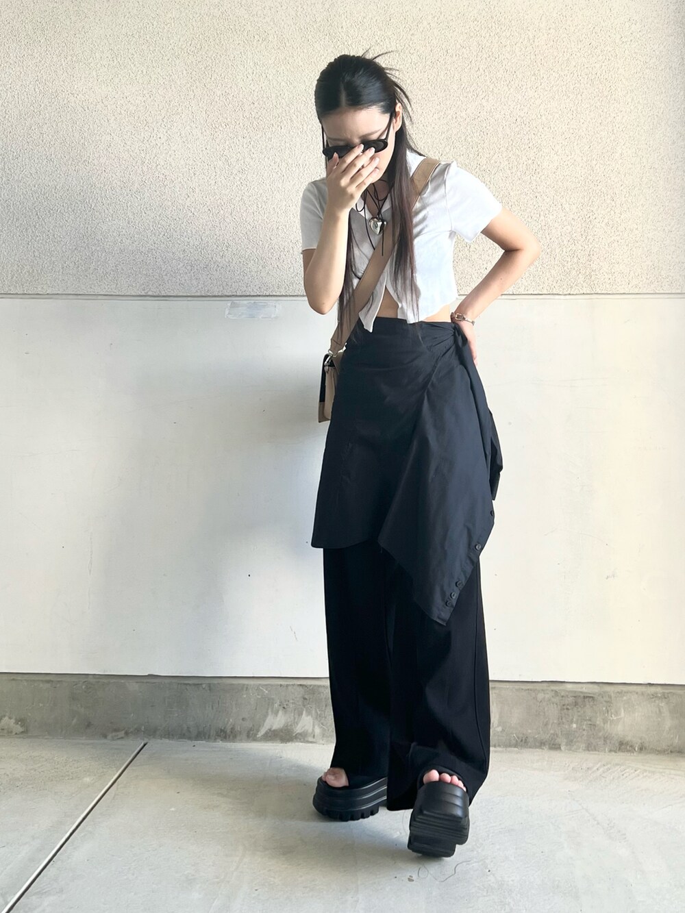 ベージュ系のショルダーバッグ、ブルー系のデニムパンツ、ブラック系のサンダルを着用したレディースの夏コーディネートの5枚目の写真