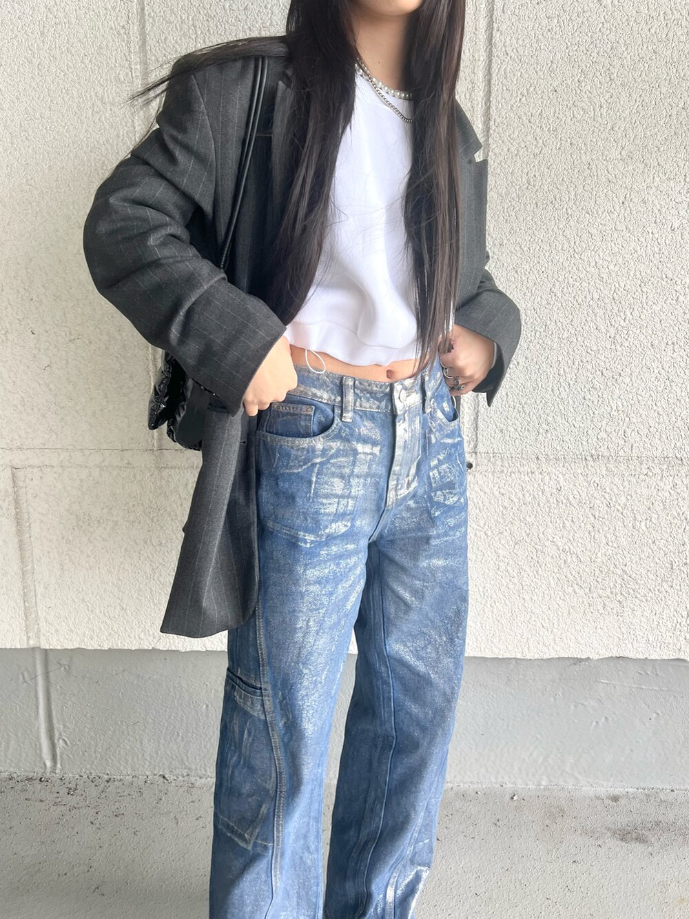 ブルー系のデニムパンツ、ブルー系のテーラードジャケット、ブラック系のトートバッグを着用したレディースの春コーディネートの2枚目の写真