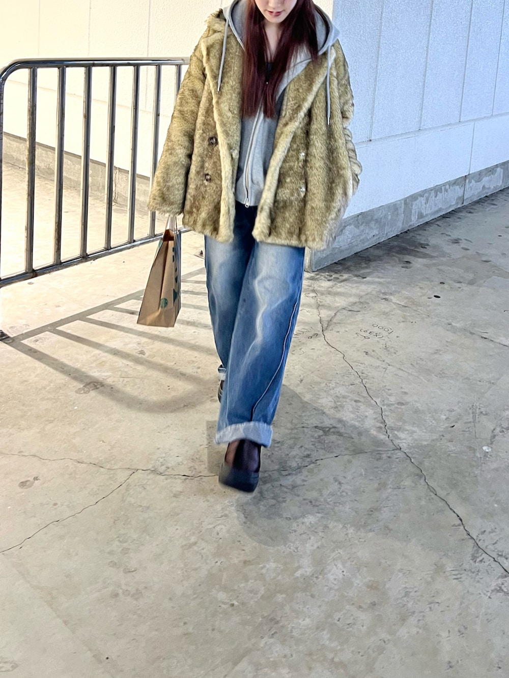 ブラウン系のスリッポン、ベージュ系のその他アウター、グレー系のパーカーを着用したレディースの冬コーディネートの2枚目の写真