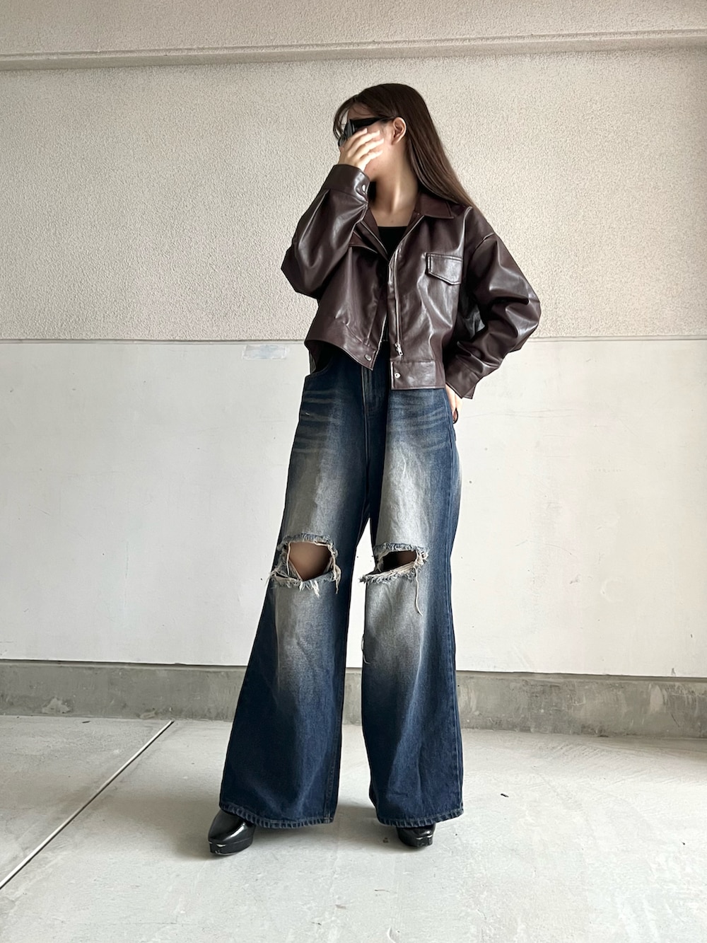 ブラック系のブーツ、ブルー系のデニムパンツ、ブラウン系のジャケット/アウターを着用したレディースの秋コーディネートの4枚目の写真