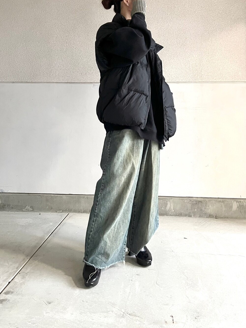 ブラック系のブーツ、ブルー系のデニムパンツ、ブラック系のトップスを着用したレディースの冬コーディネートの5枚目の写真