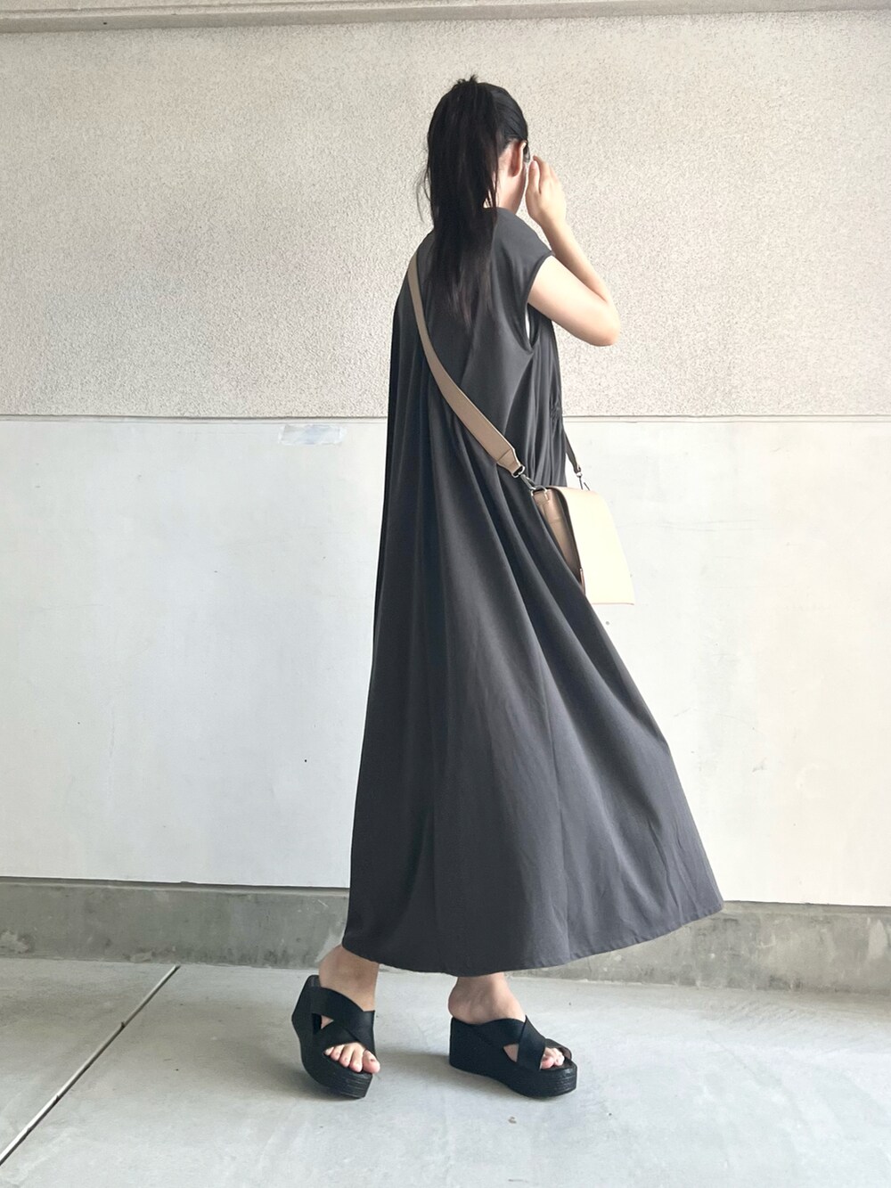 グレー系のワンピース、ベージュ系のショルダーバッグ、ブラック系のシューズを着用したレディースの夏コーディネートの4枚目の写真