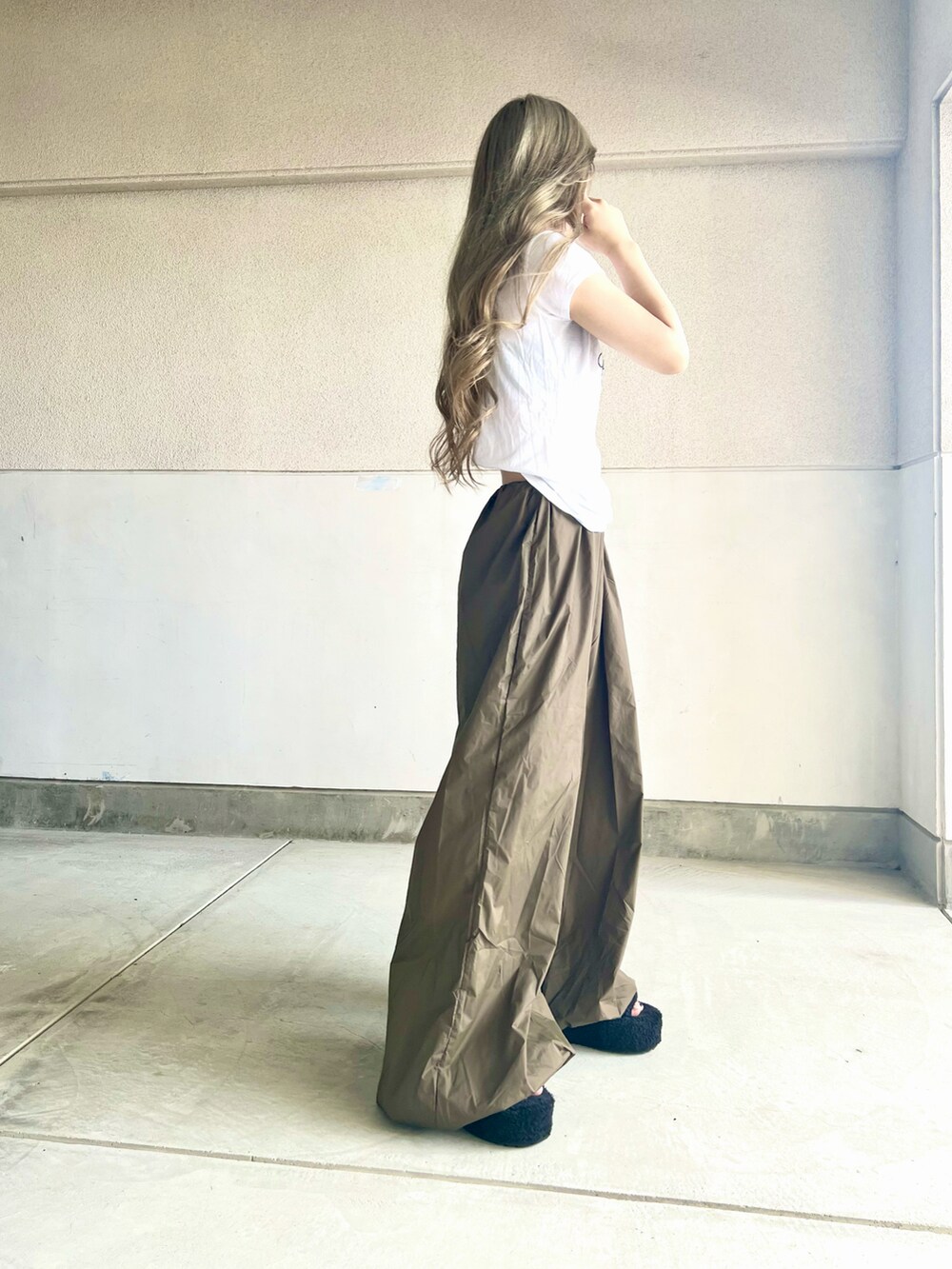 ブラック系のバッグ、ホワイト系のTシャツ/カットソー、グリーン系のパンツを着用したレディースの夏コーディネートの3枚目の写真