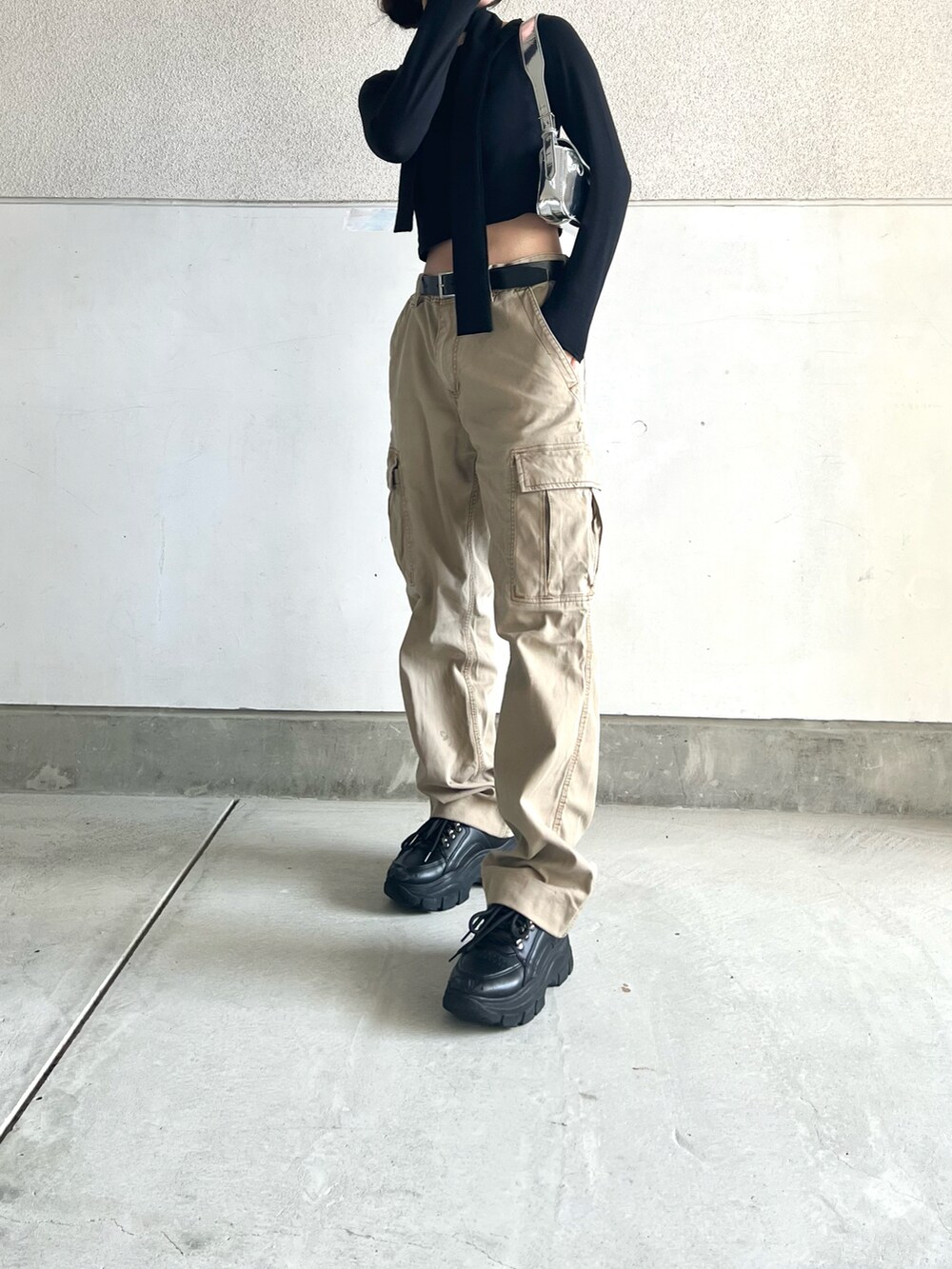 ベージュ系のカーゴパンツ、ブラック系のスニーカー、ブラック系のTシャツ/カットソーを着用したレディースの春コーディネートの3枚目の写真