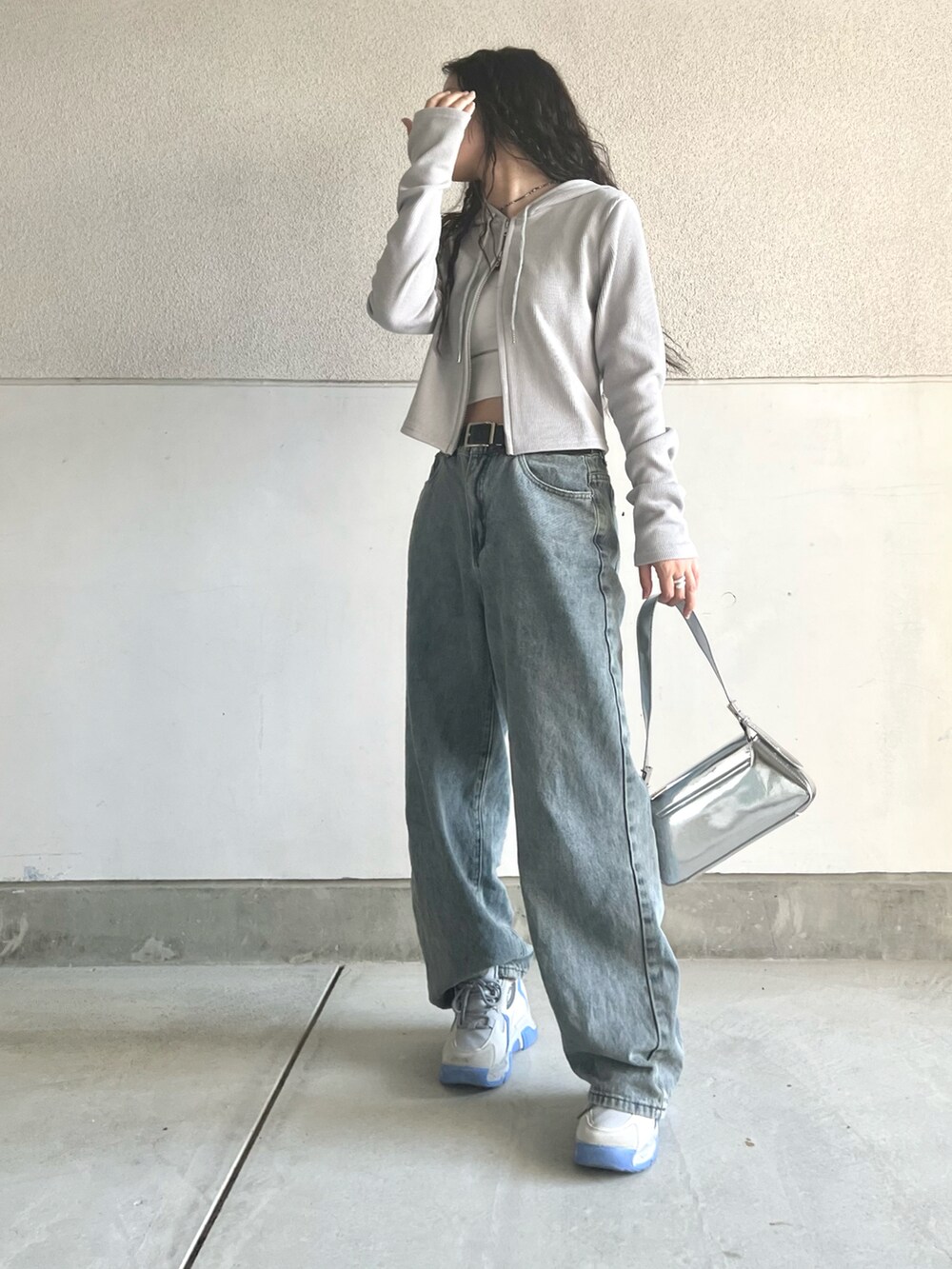 グレー系のスニーカー、グレー系のパーカー、ブルー系のデニムパンツを着用したレディースの春コーディネートの4枚目の写真