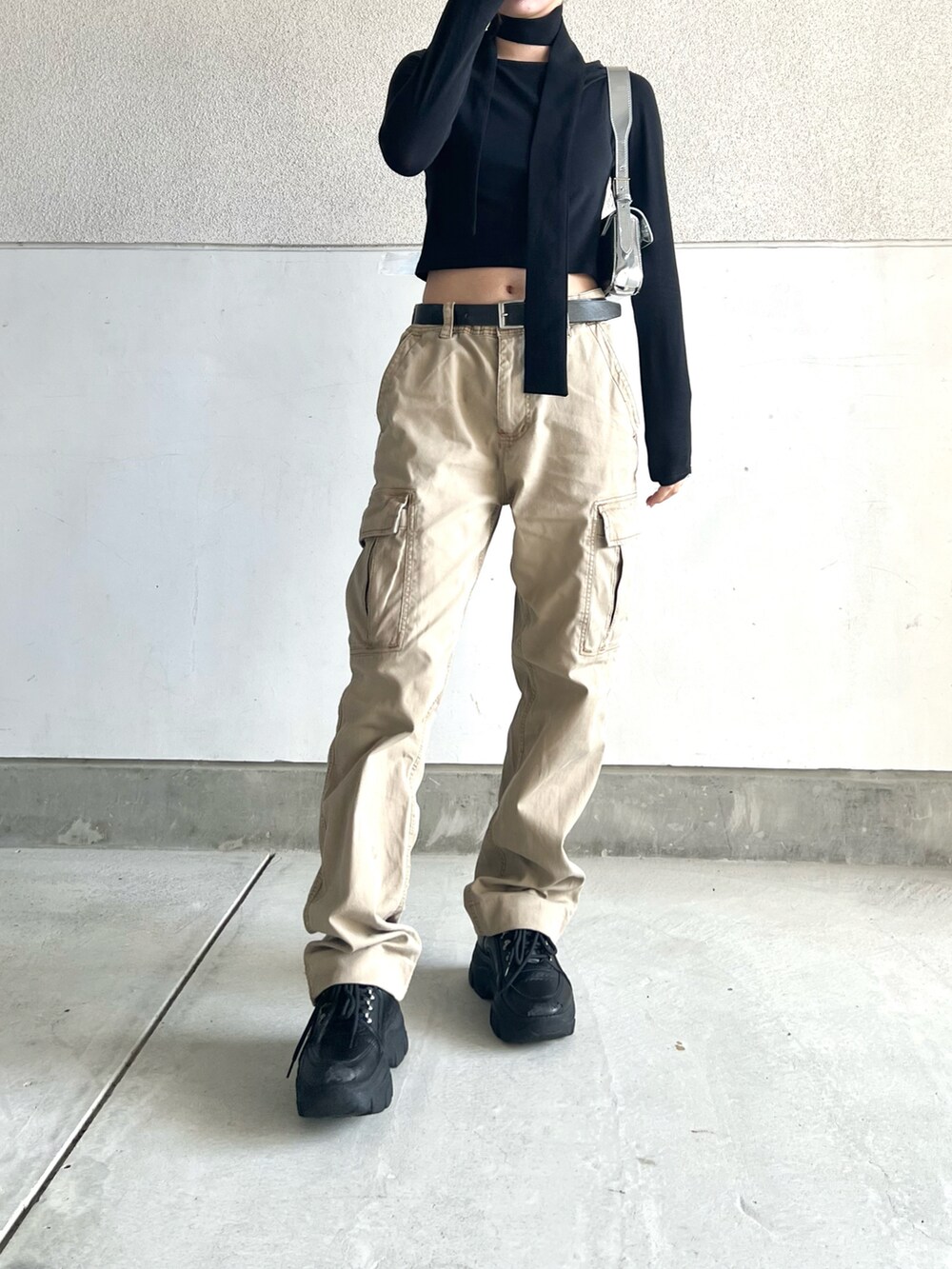 ベージュ系のカーゴパンツ、ブラック系のスニーカー、ブラック系のTシャツ/カットソーを着用したレディースの春コーディネートの4枚目の写真